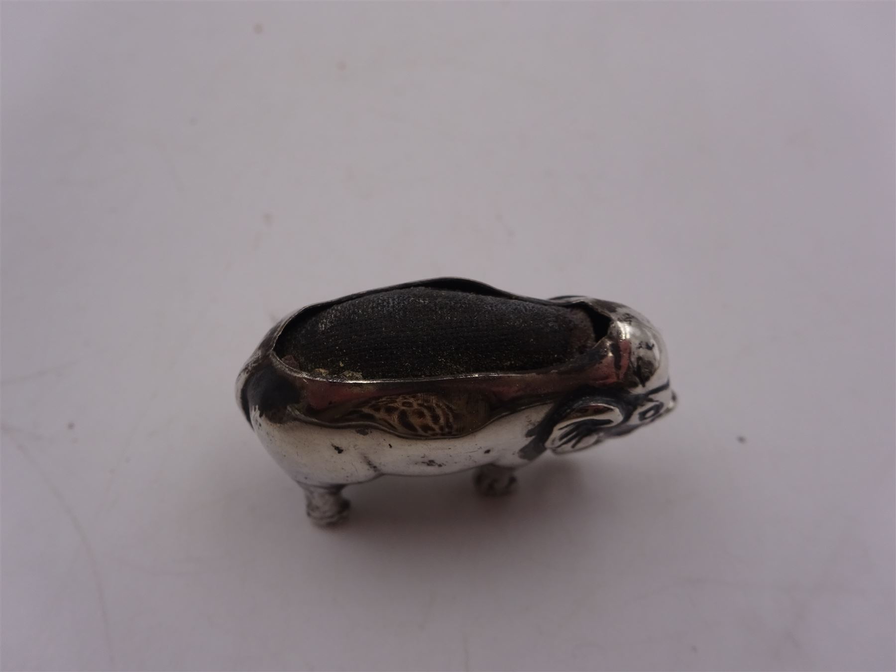 Edwardian silver mounted novelty pin cushion, in the form of an elephant, with cushioned back, hallmarked Birmingham 1906, maker's mark worn and indistinct, L4cm, H3.5cm