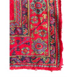 Early 20th century Western Anatolia Turkish Oushak crimson ground carpet, the field decorated with rows of Herati and Palmette medallions, the main border decorated with stylised flower head motifs within guard stripes