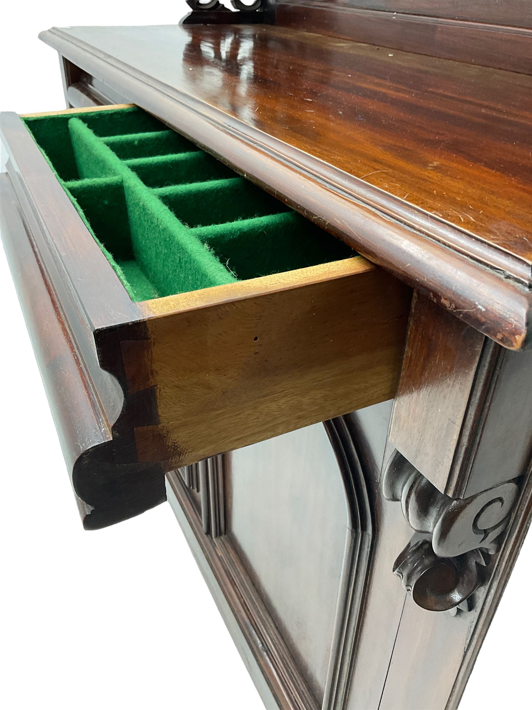 Victorian mahogany chiffonier, raised shaped back with foliage scroll carved mounts, on fretwork and carved bracket supports, moulded rectangular top over two frieze drawers and double panelled cupboard, on moulded plinth base