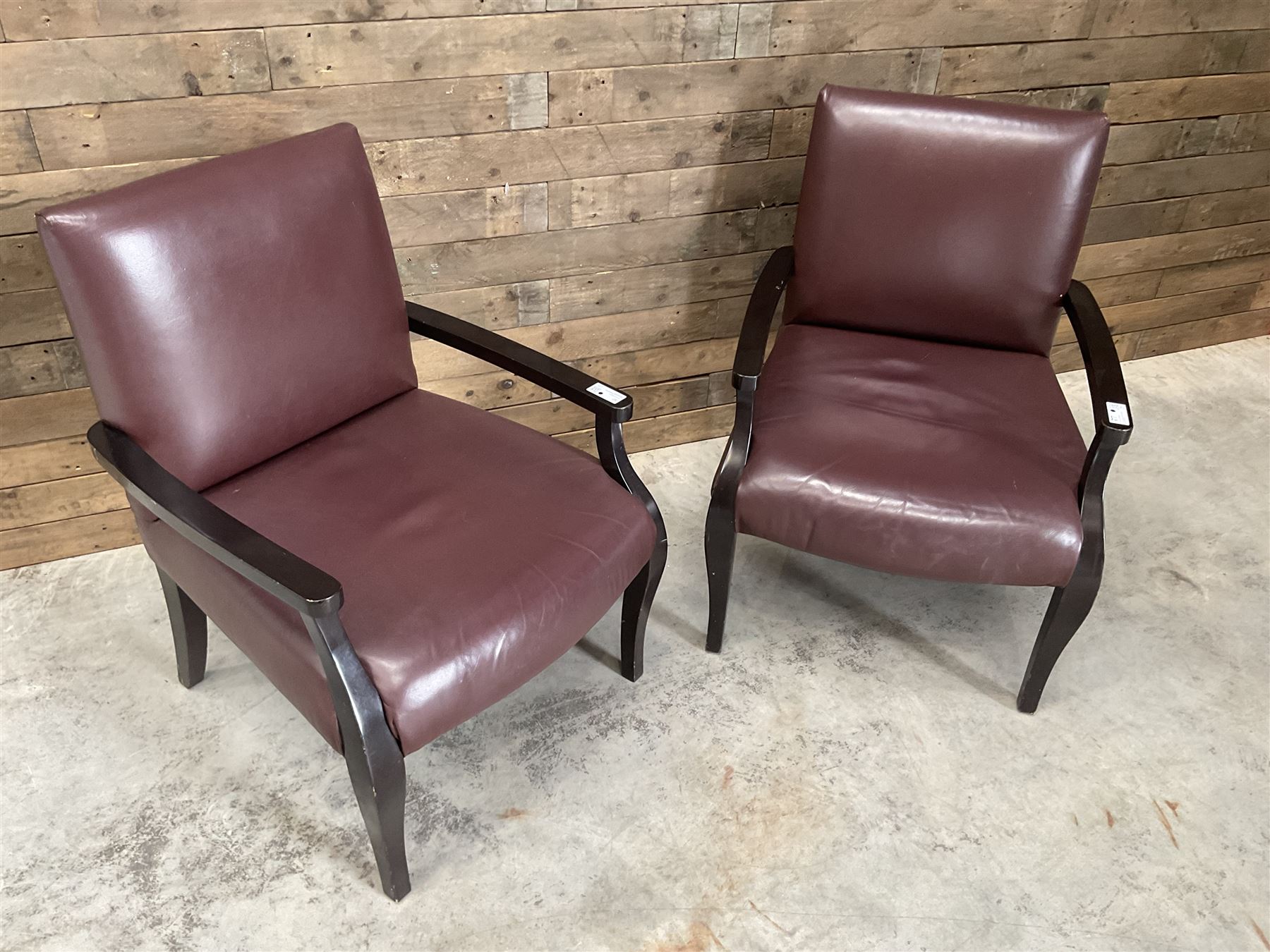 Two rosewood framed armchairs, upholstered in brown leather