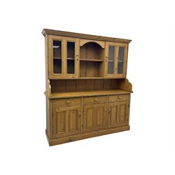 Large pine dresser, raised display cabinets over three drawers and three panelled cupboards, on plinth base