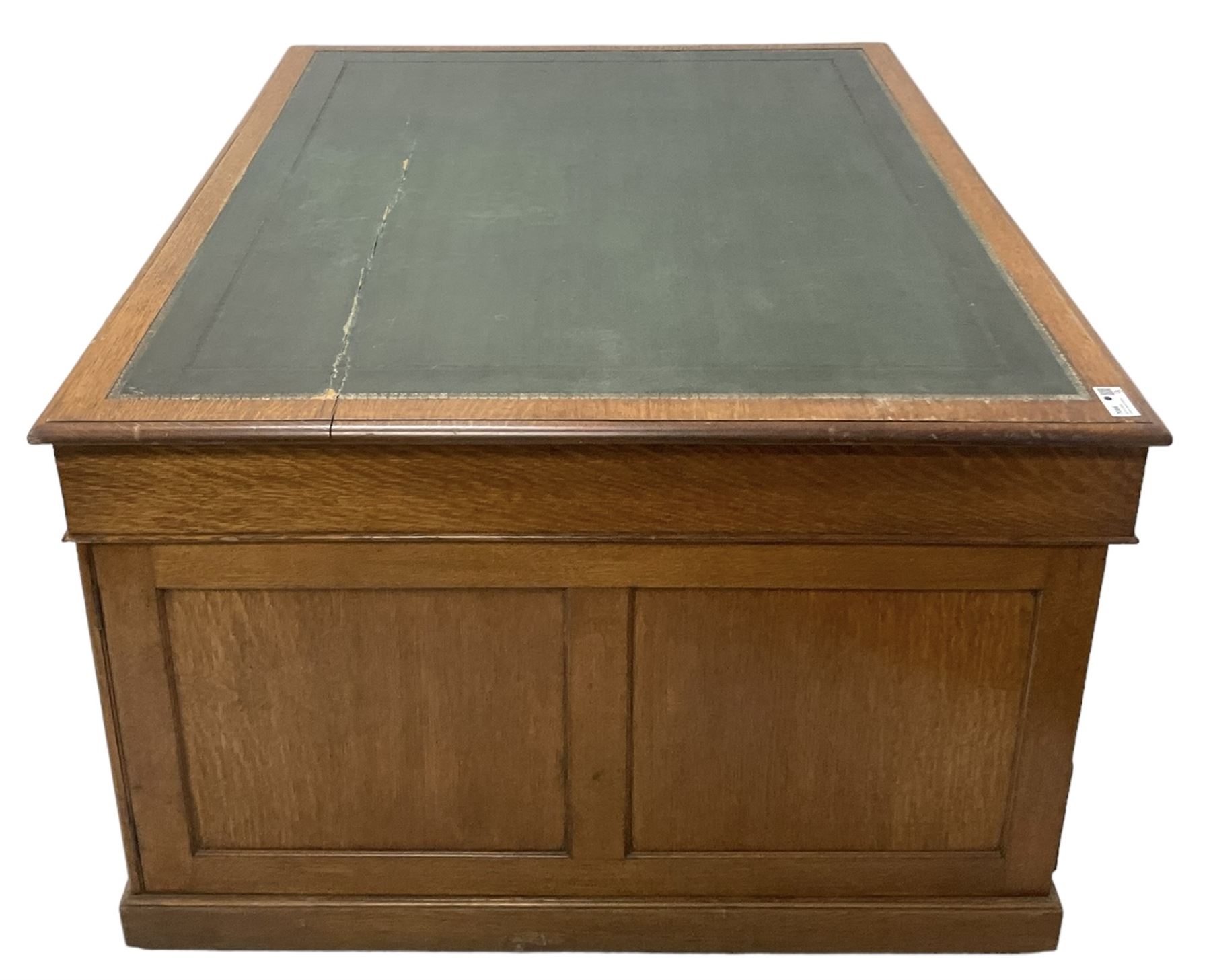 Late 19th century twin pedestal oak partner's desk, rectangular top with inset green leather writing surface, fitted with nine graduating drawers to each side, the rear drawers enclosed by panelled cupboards