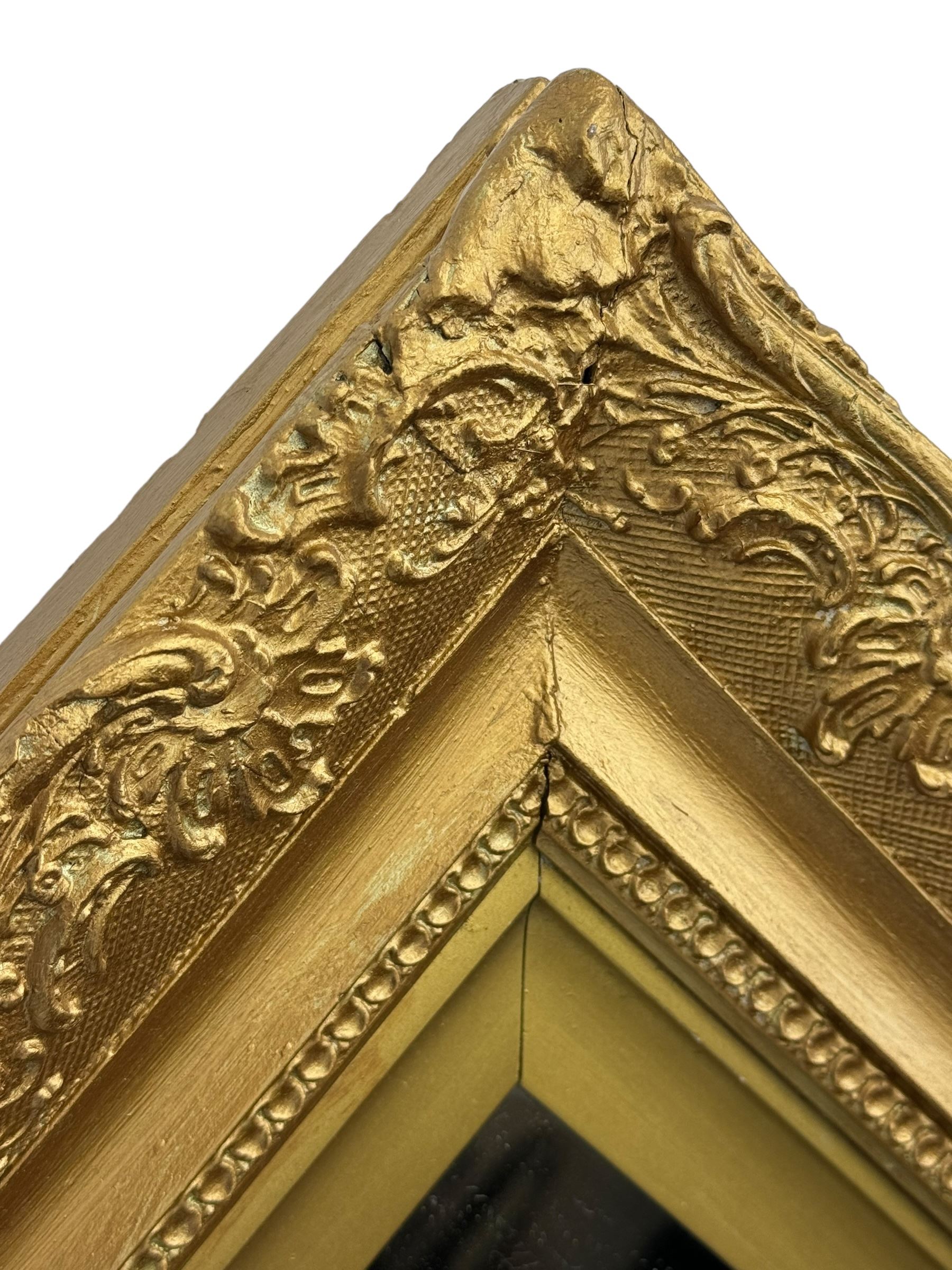 Rectangular wall mirror, in ornate gilt frame decorated with trailing leafy branches and flower heads 