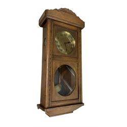 Two train oak cased wall clock, striking the hours on a coiled gong. With pendulum and key.