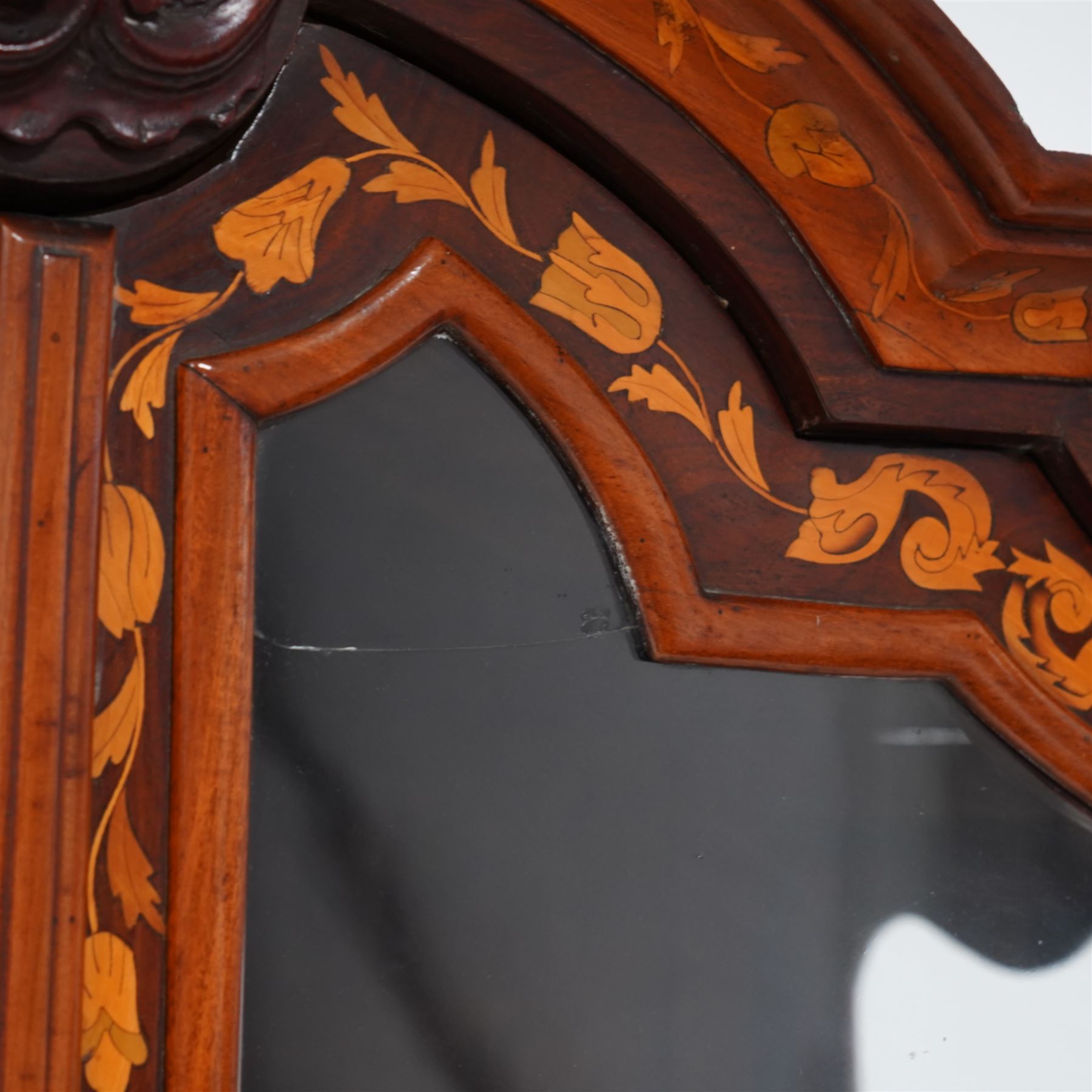 18th century Dutch marquetry walnut and gilt metal mounted vitrine cabinet on chest, shaped pediment carved with scrolling foliage cartouche, inlaid with trailing leafy branches and flower heads, two internal shelves enclosed by two glazed doors, the lower section with bombe outline fitted with three drawers, with ornate cast gilt metal edging and terminal caps