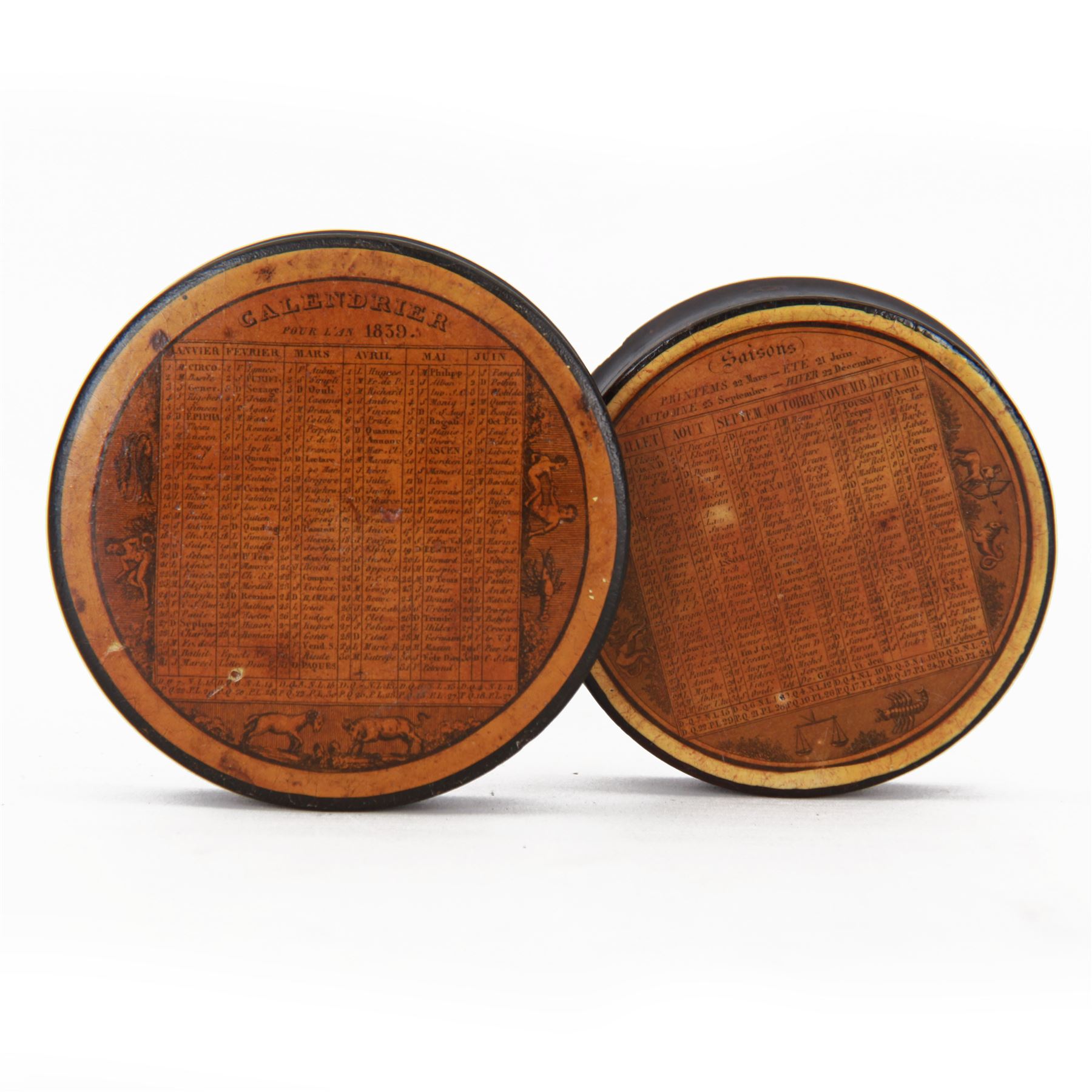 Two 19th century French papier-mâché snuff boxes, each of circular form decorated with the French calendar and detailed 'Calendrier pour l'an 1839' and 'Calendrier pour l'annee 1844' to top and ''Saisons' to base, further detailed with the months, days and additional notations alongside symbols from the zodiac, larger example D9.5cm, smaller example D8.5cm