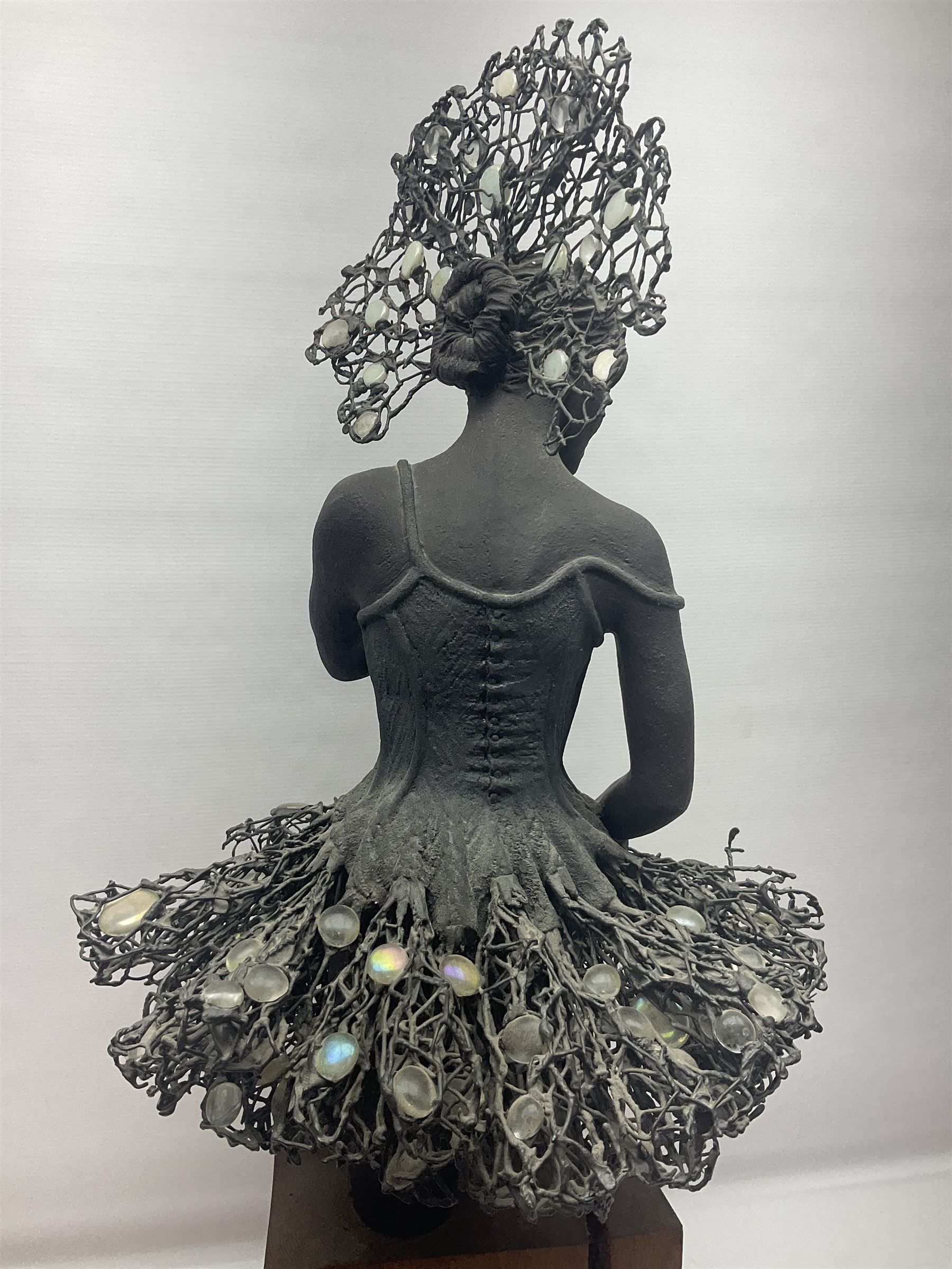 Composite bronzed sculpture, modelled as a ballerina, the skirt and head dress 
 set with glass cabochons, upon a rectangular wooden plinth, H92cm