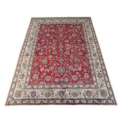 Large Fine Persian Kashan rug, red ground field decorated with large stylised flower heads, the ivory ground border with matching motifs and trailing foliage