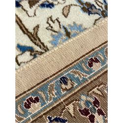 Persian Nain ivory ground carpet, the field decorated all over with leafy branches and stylised flower head motifs, blue ground central medallion and matching spandrels decorated with trailing foliate pattern, repeating guarded border with overall floral design