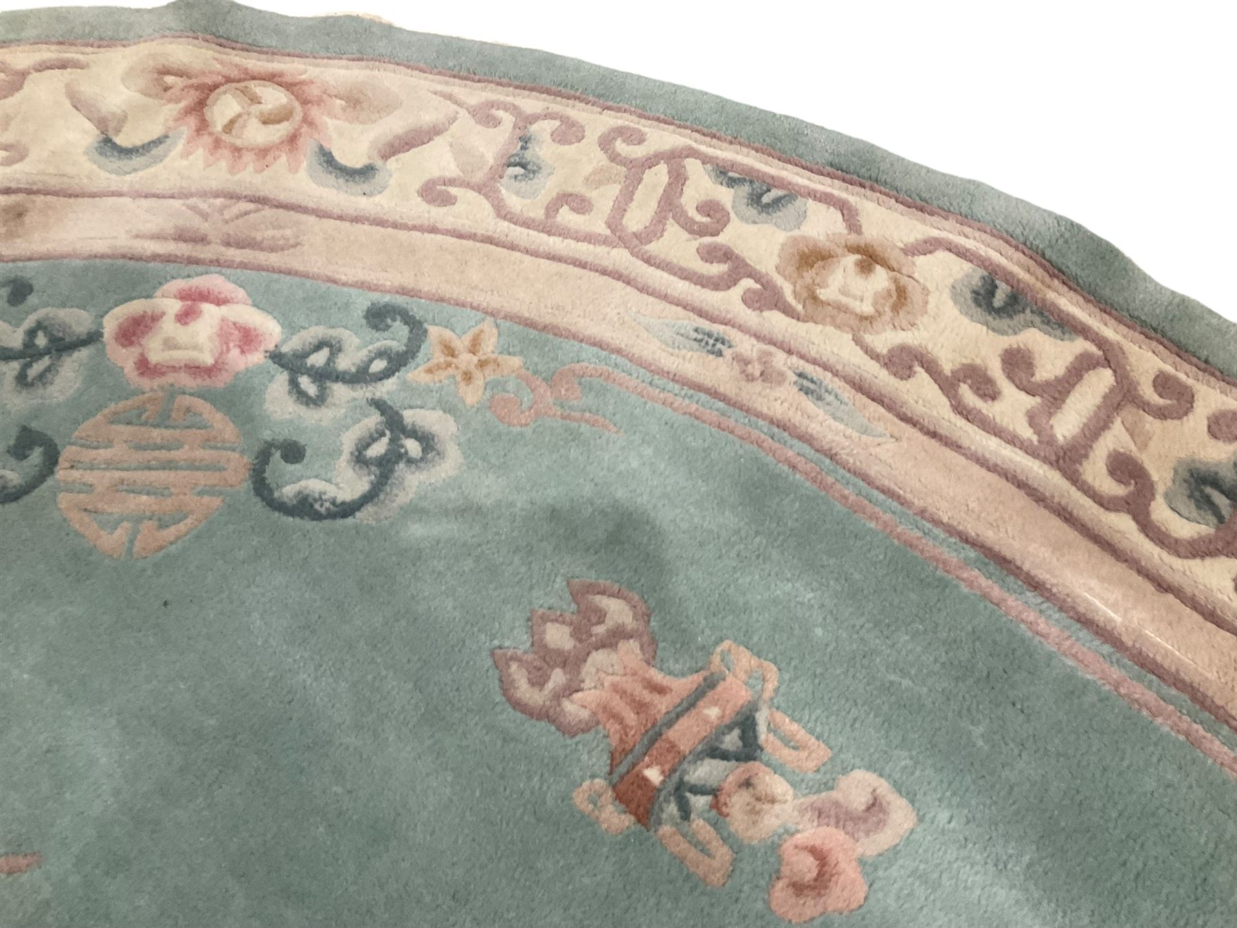 Chinese pale turquoise ground washed woolen rug, oval form decorated with bouquets of floral designs and Chinese characters, enclosed by a wide guard band