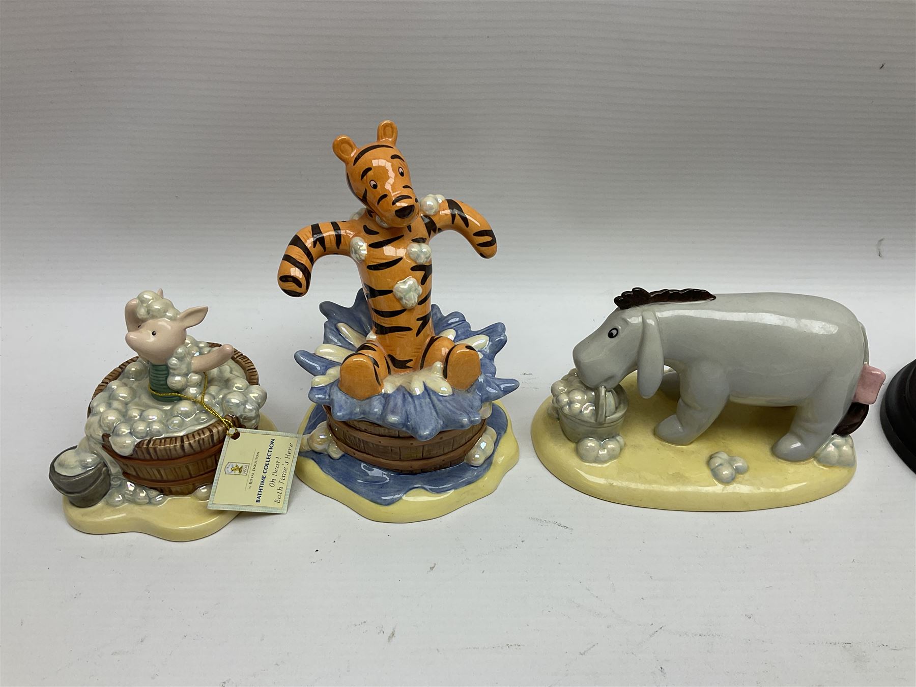 Nine Royal Doulton Winnie the Pooh Collection figures, including Oh Dear Bath Time's Here, Going Sledging, Tigger's Splash Time and Christopher Robin, together with a Royal Doulton Disney Showcase Jiminy Cricket figure, all boxed