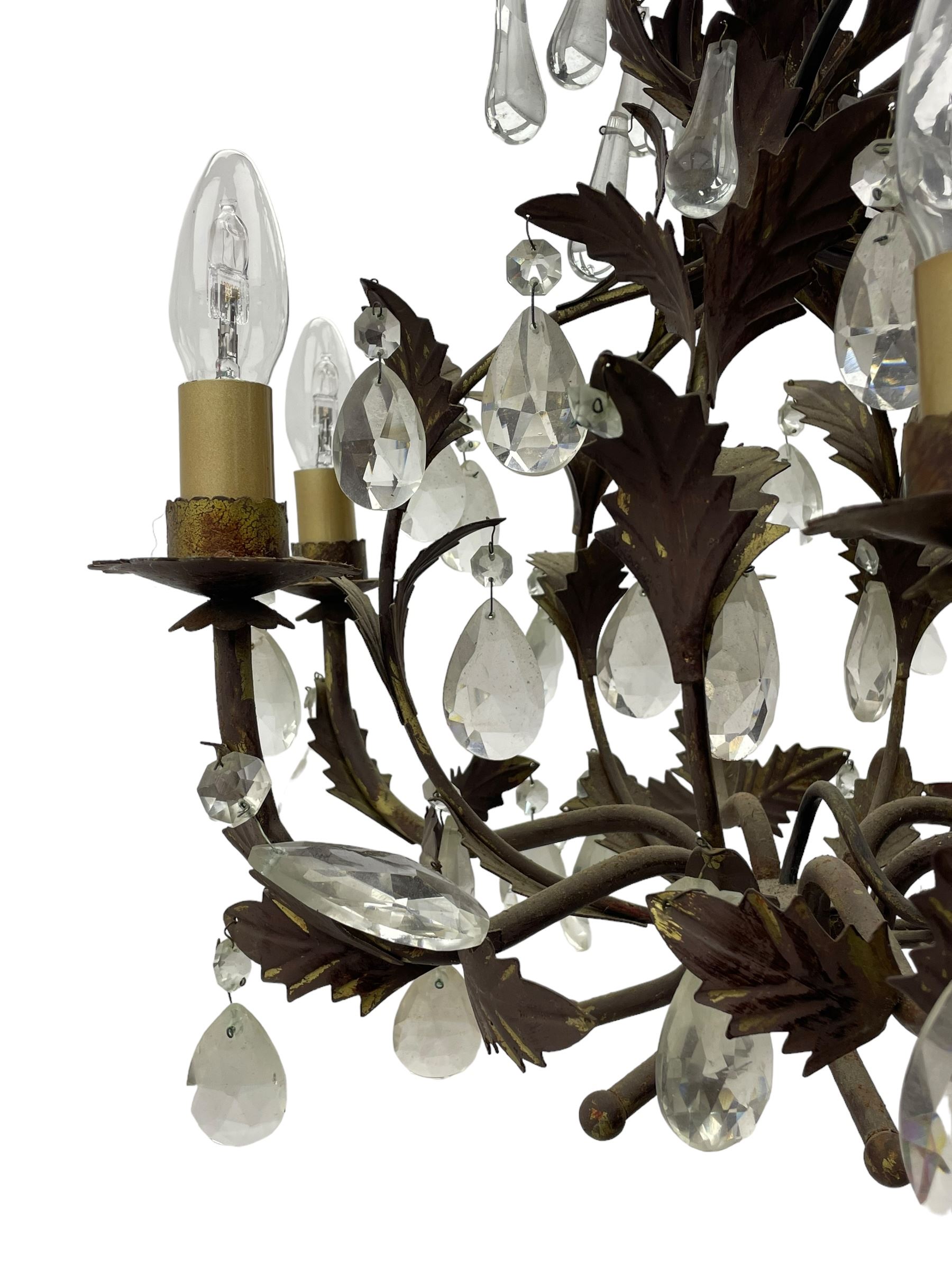 Early 20th century wrought metal chandelier, of scrolled form with six branches, decorated with leafage and glass pendants 