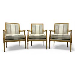 Three mid-20th century beechwood fauteuil armchairs, upholstered backrest and seat in crea...