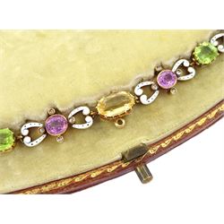 Early 20th century 15ct gold gold orange / yellow / peach topaz, pink tourmaline, pink sapphire peridot and diamond necklace, the pinks stones each set with four rose cut diamonds and spaced by scroll links with white enamel and black dots, to a trace link chain necklace, in fitted silk and velvet lined box by Skinner & Co