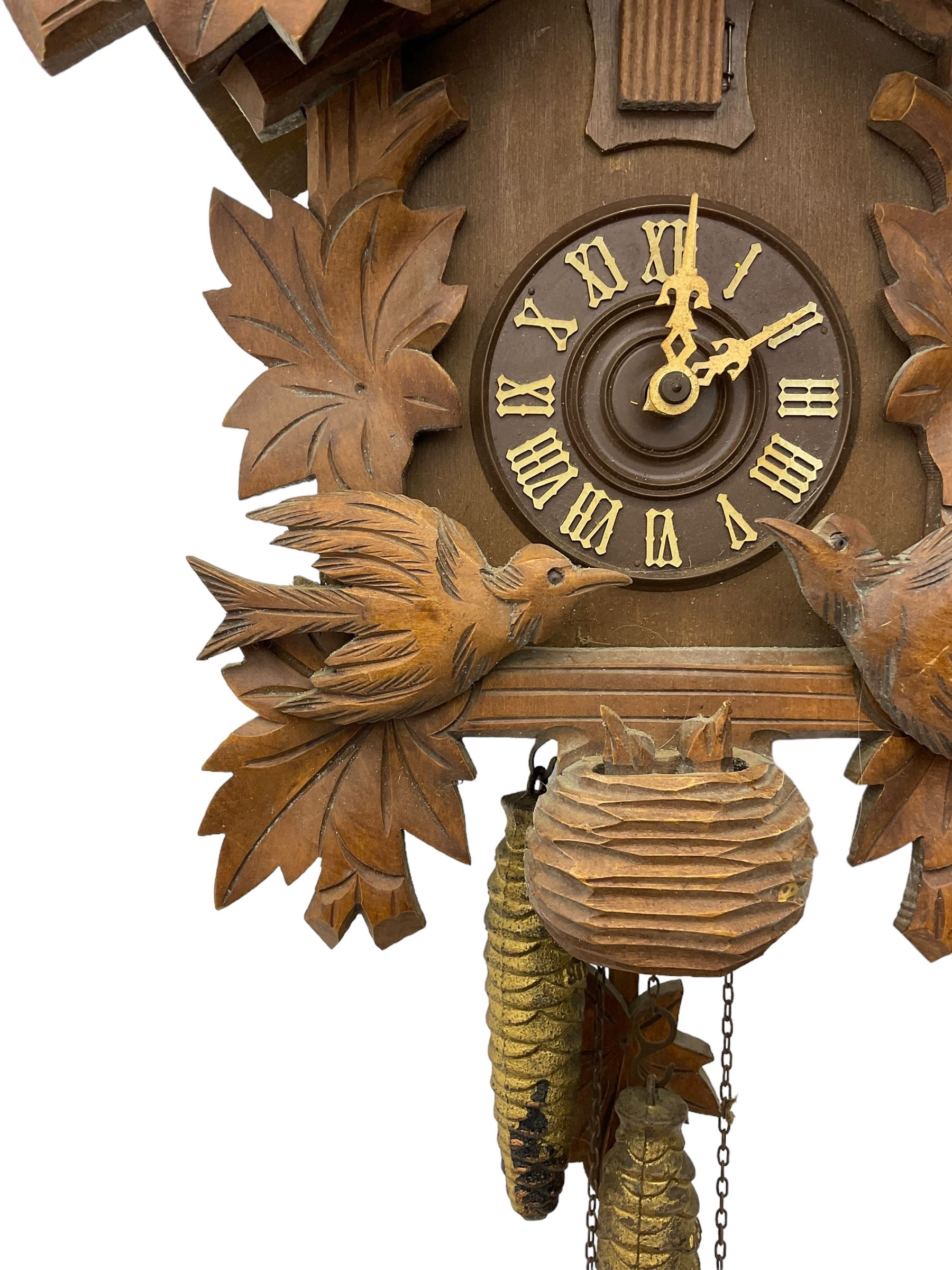 German 1960's cuckoo clock with automata - traditional styled case and dial with a cuckoo sounding the hours and half-hours, twin chain driven movement and automata feature of two carved cuckoos to the front of the case simultaneously moving as the hours are struck. With weights and pendulum.  