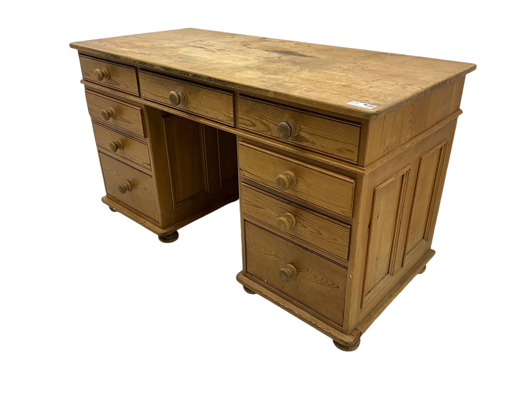 Waxed pine twin pedestal desk, rectangular top over nine drawers, on compressed bun feet 