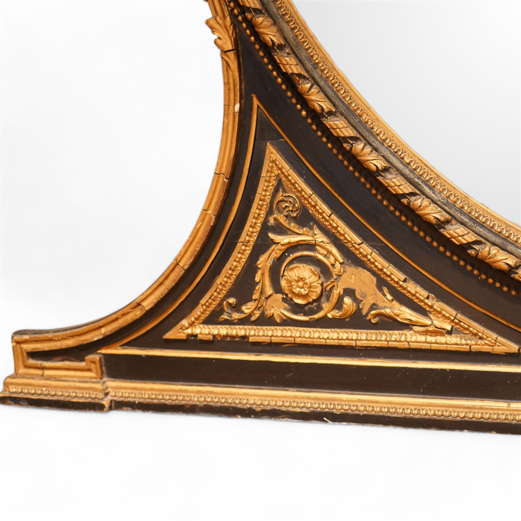 Large 19th century ebonised and parcel-gilt overmantle mirror, the oval plate within a gilt slip, framed by acanthus ribbon-twist decoration with outer beading, the shaped base decorated with scrolling foliate patterns and rosettes