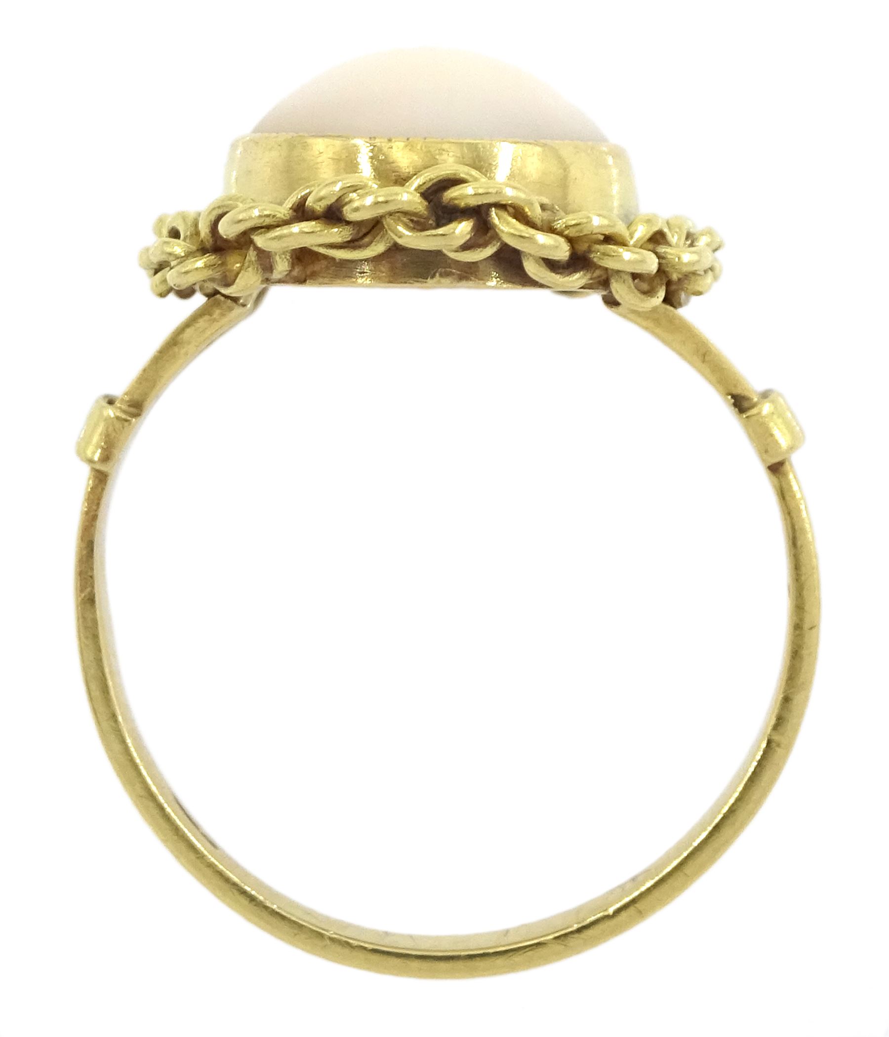 18ct gold single stone coral ring, with chain decoration border, stamped 750