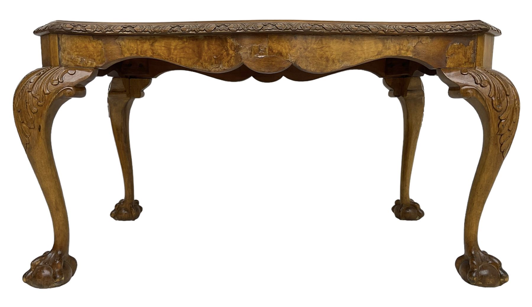 Mid-20th century figured walnut serpentine coffee table, inset glass top and foliate carved edge, raised on cabriole supports with acanthus moulded knees and ball and claw feet