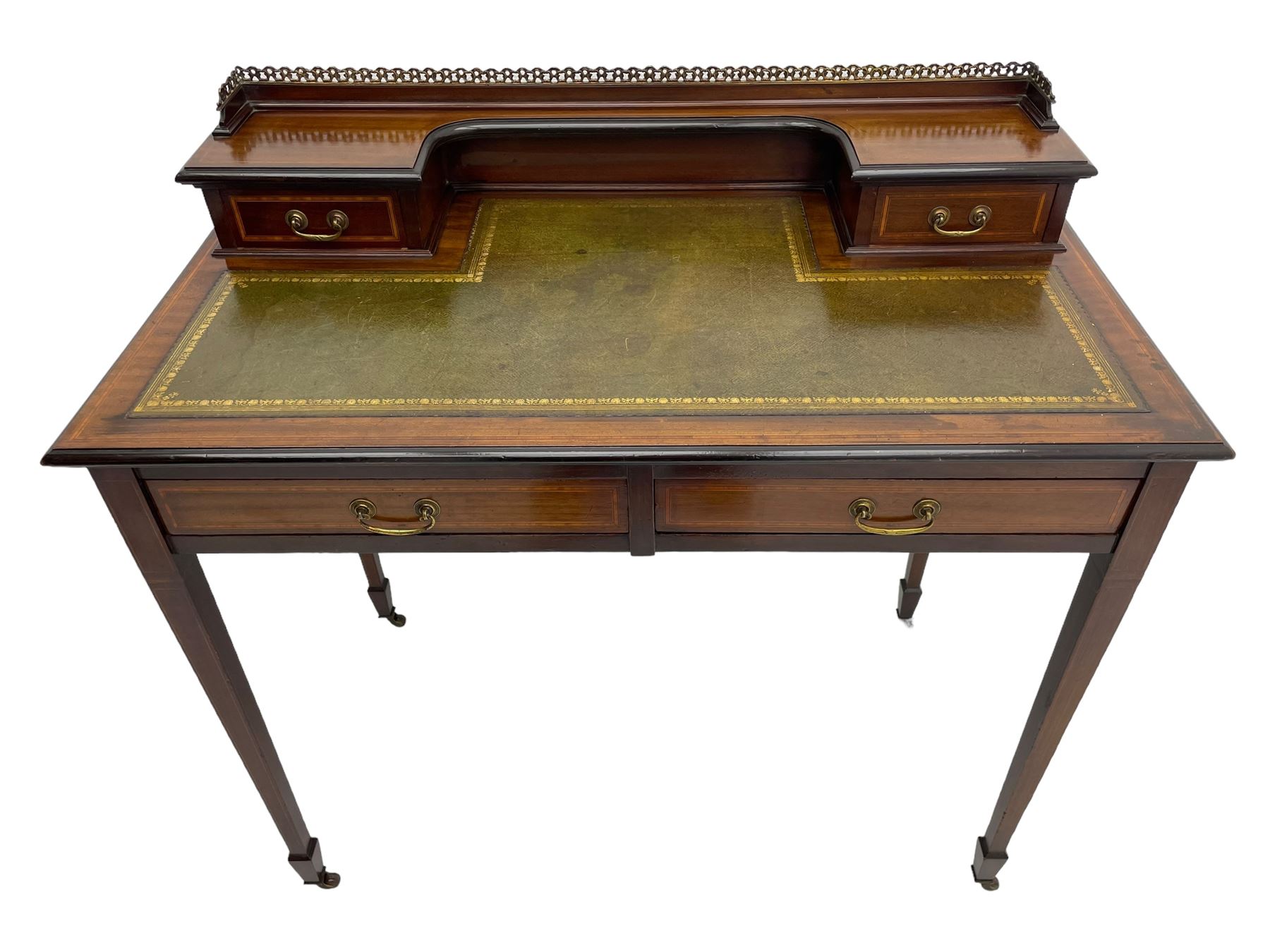 Edwardian inlaid mahogany writing desk, raised back with gilt metal gallery over two small drawers with satinwood banding, the rectangular moulded top with green leather inset writing surface, fitted with two drawers, on square tapering supports with spade feet, brass and ceramic castors 