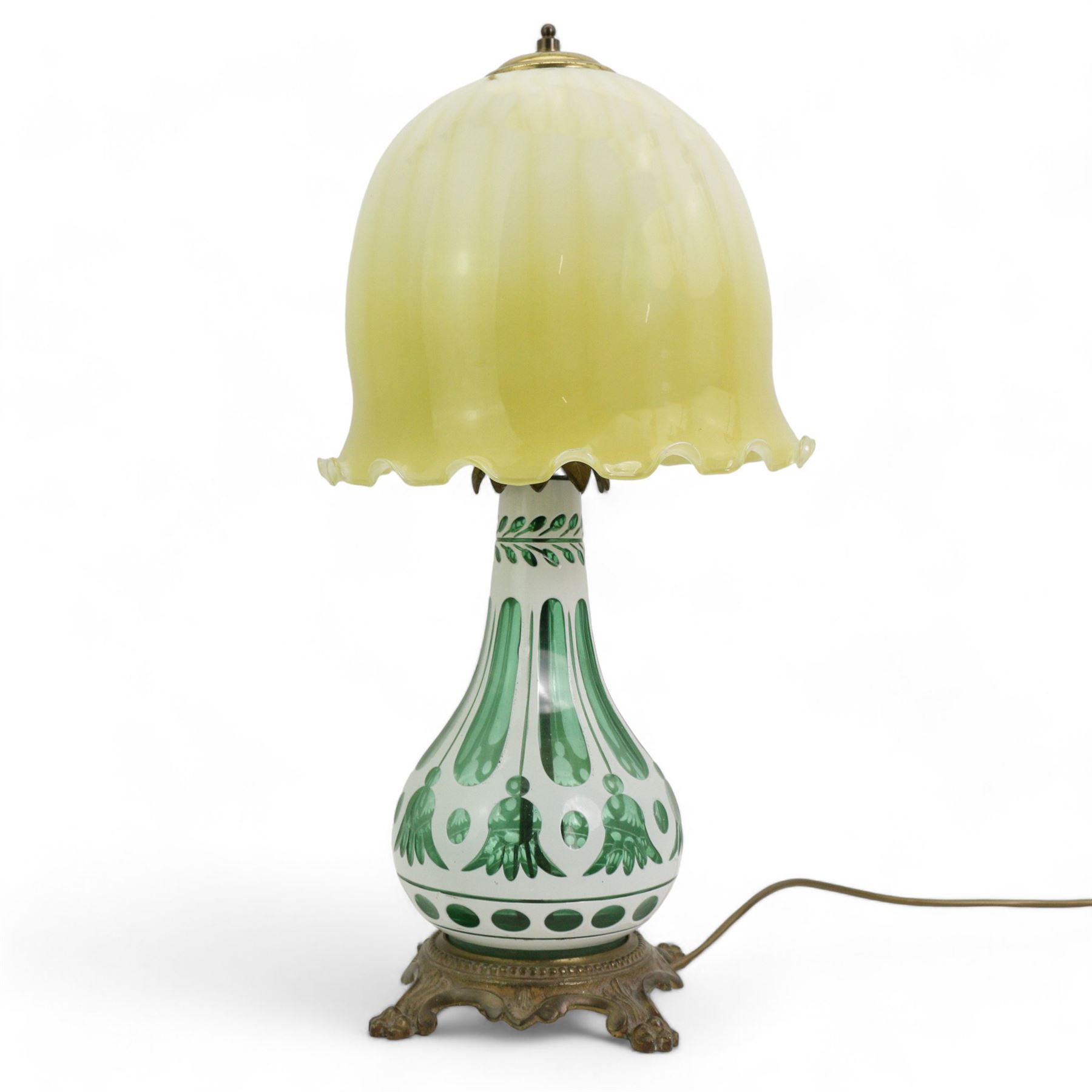 Early 20th century Bohemian green and white glass overlaid table lamp, of bulbous form with tapering neck, decorated with flower heads, with associated butterscotch mushroom form glass shade with wavy rim, on a cast brass base with four lion paw supports, H53cm