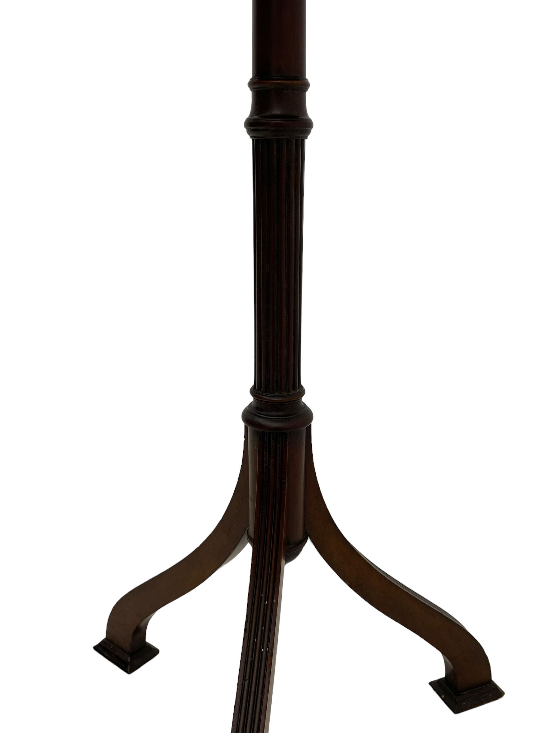 Early 20th century mahogany wine table, figured circular top with reeded edge, on turned and reed moulded stem, three reeded tapered supports on rectangular moulded pad feet 