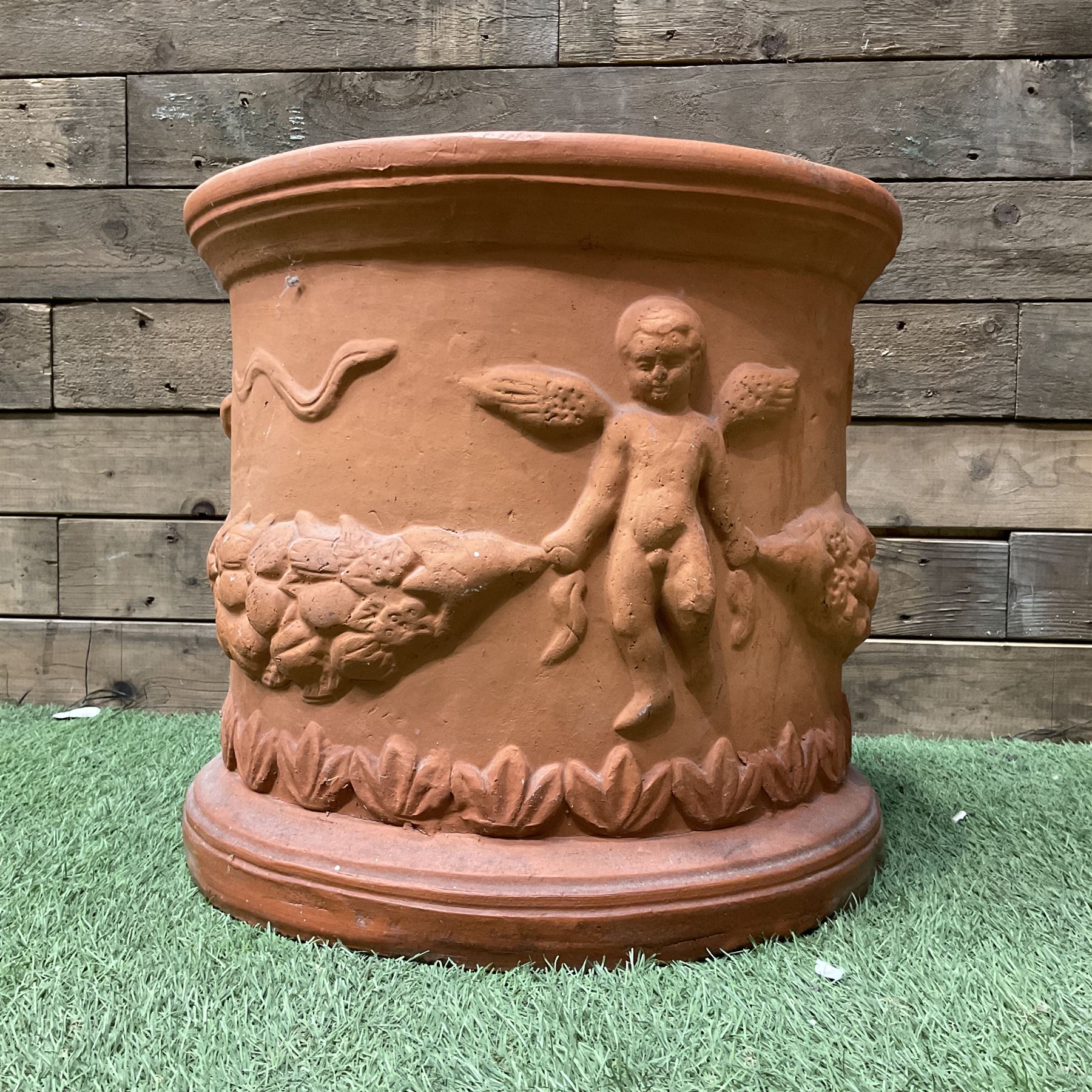 Circular terracotta garden planter, decorated with cherubs and terracotta urn on plinth - THIS LOT IS TO BE COLLECTED BY APPOINTMENT FROM DUGGLEBY STORAGE, GREAT HILL, EASTFIELD, SCARBOROUGH, YO11 3TX