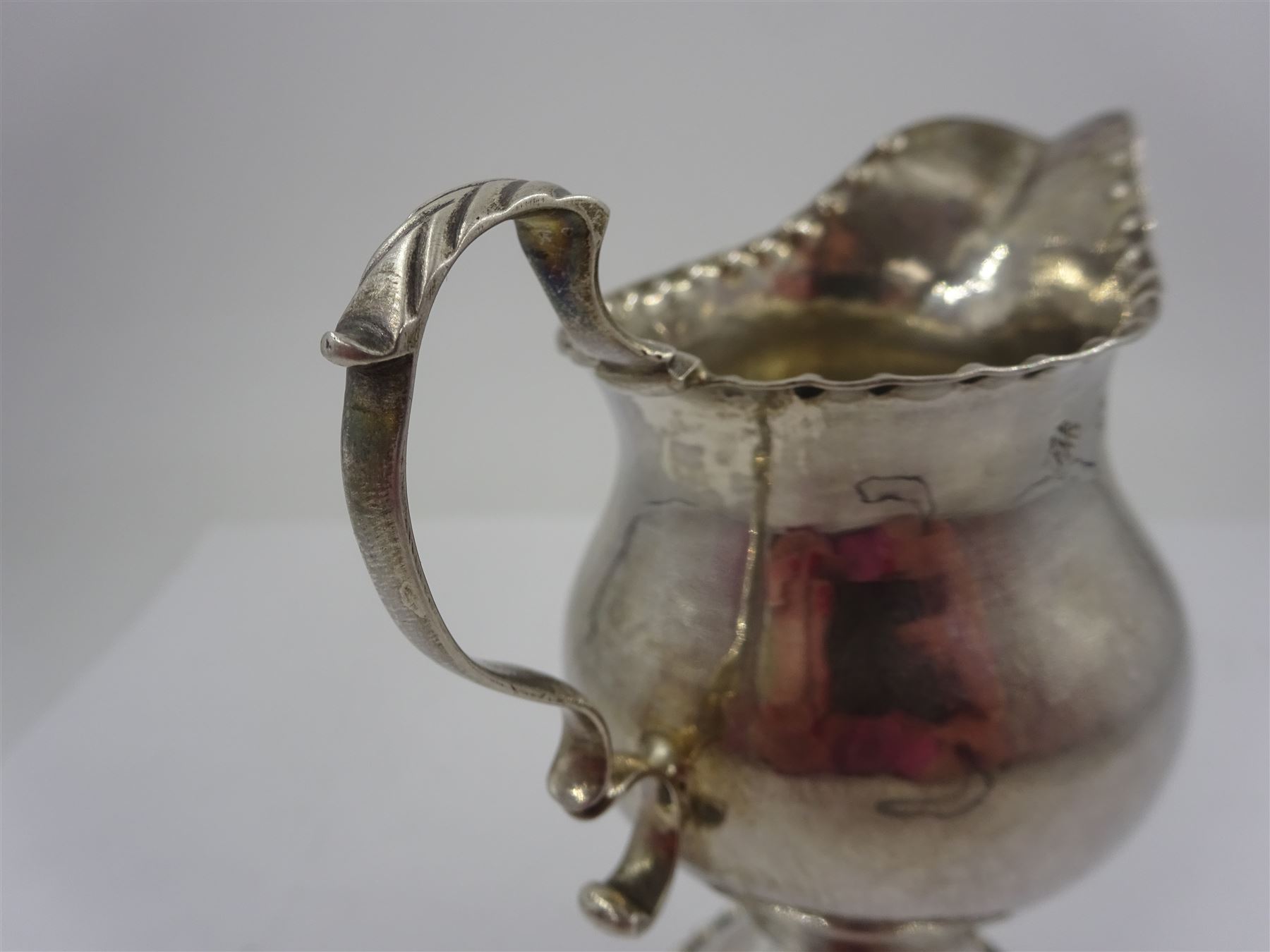 George III silver pedestal cream jug, with acanthus capped scroll handle, the body with lightly hammered and stipple decoration, upon circular foot, hallmarked Ann Smith & Nathaniel Appleton, London 1779, H11cm