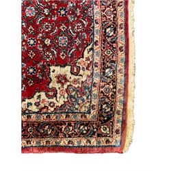 Persian design crimson ground rug, the field decorated with central floral pole medallion and surrounded by foliate patterns with matching spandrels, guarded border with repeating palmette motifs