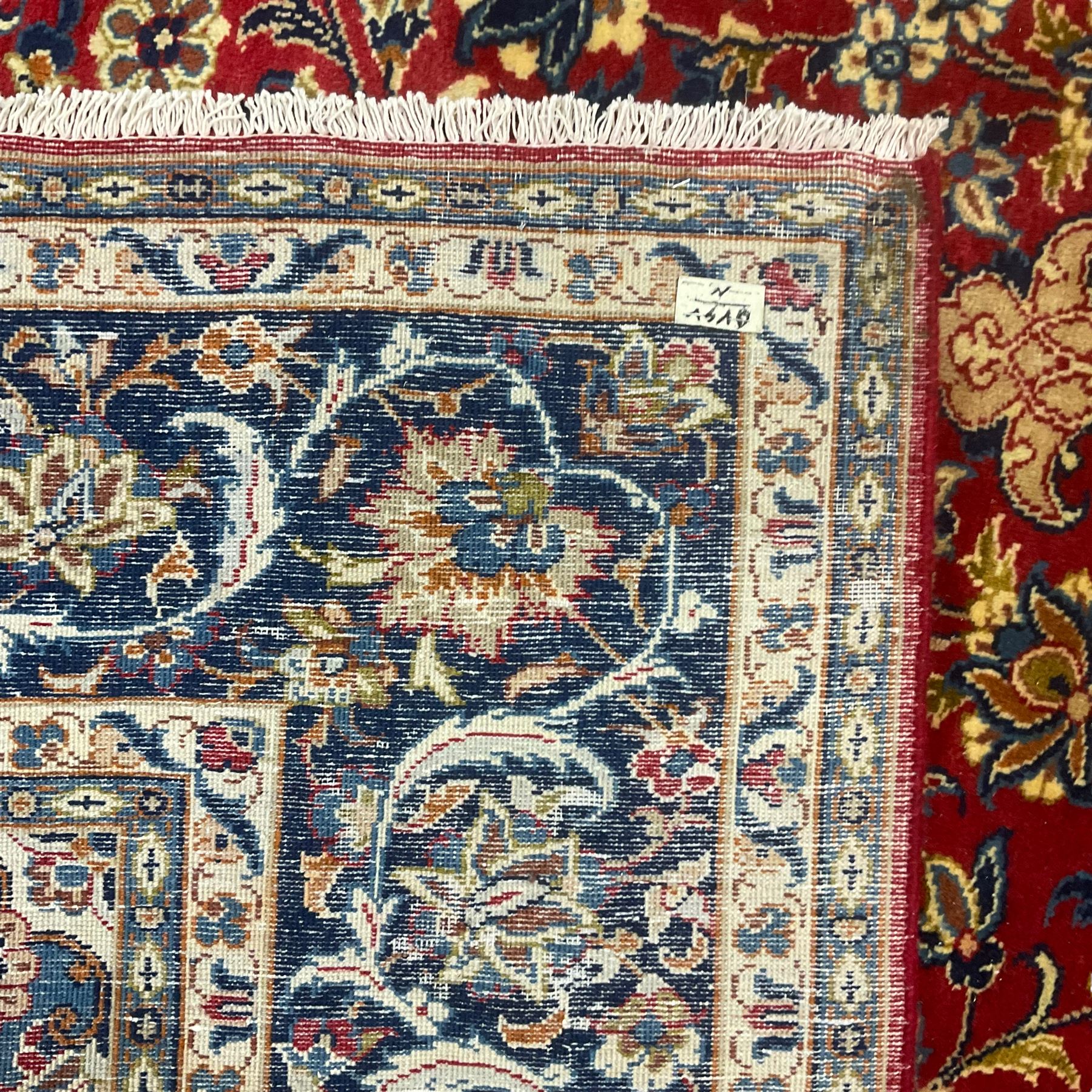 Persian Kashan red ground carpet, the field decorated with central medallion surrounded by trailing branches and stylised plant motifs, blue ground border with scrolling floral design 