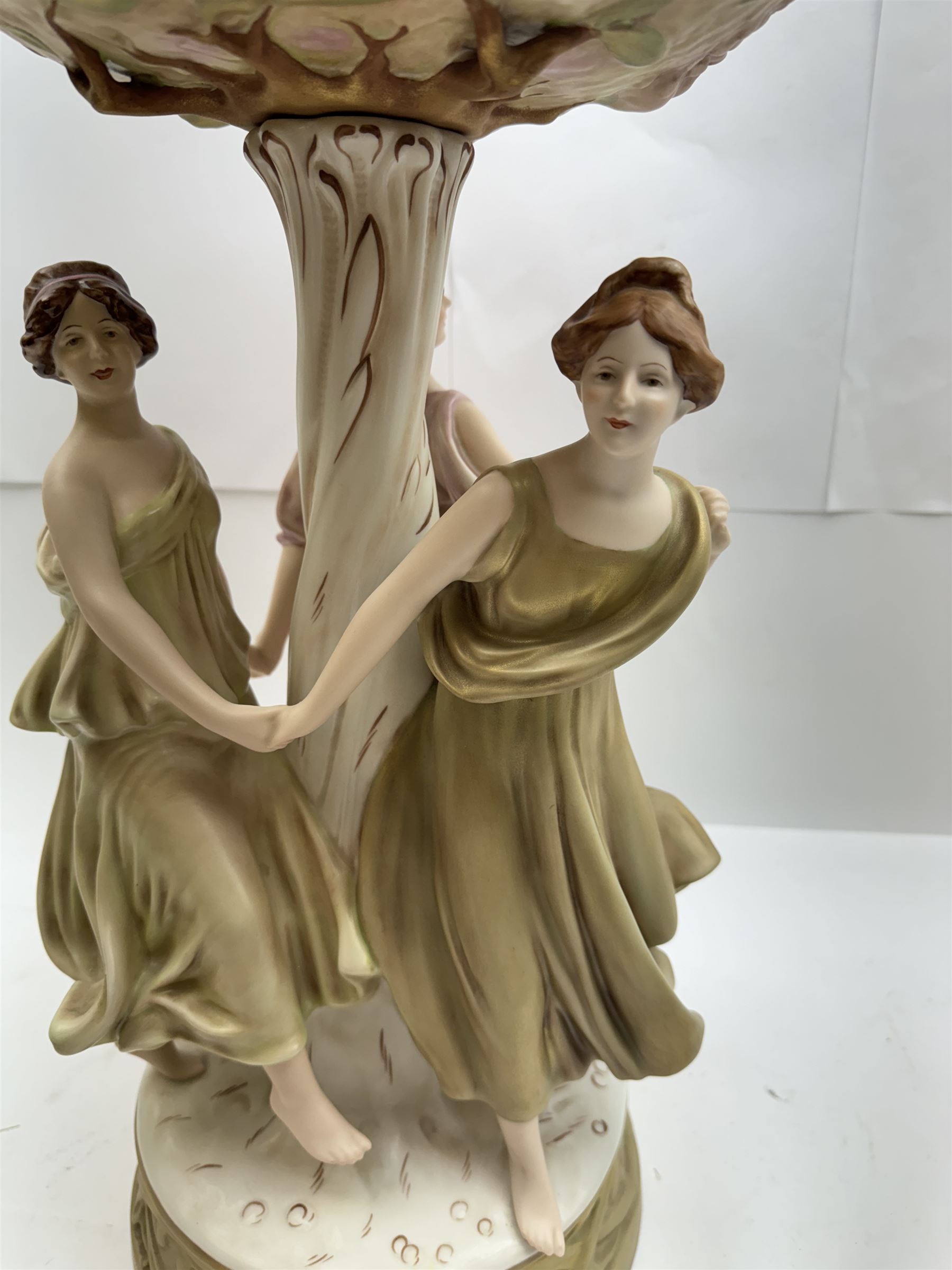 Royal Dux centrepiece, modelled as the Three Graces beneath a floral compote, upon a circular base, H51cm