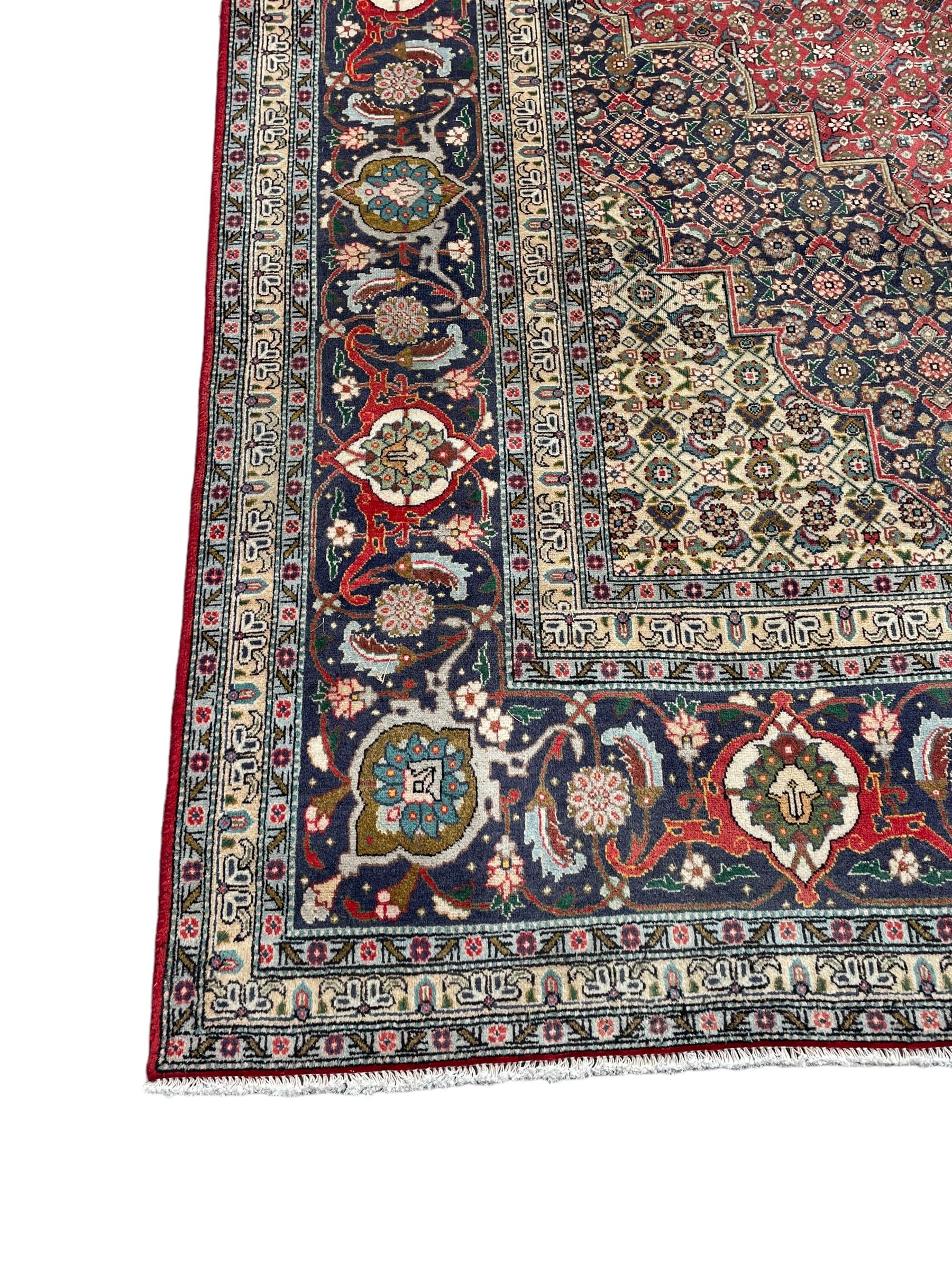 Perisian Bidjar crimson ground rug, within scalloped borders, central pole medallion, the field decorated all over with floral Herati motifs, guarded border decorated with repeating stylised plant motifs and trailing branch 