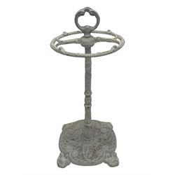 Victorian design cast iron umbrella stand, ornate stem on shell C-scroll base; together with a collection of walking sticks including a silver tipped cane 