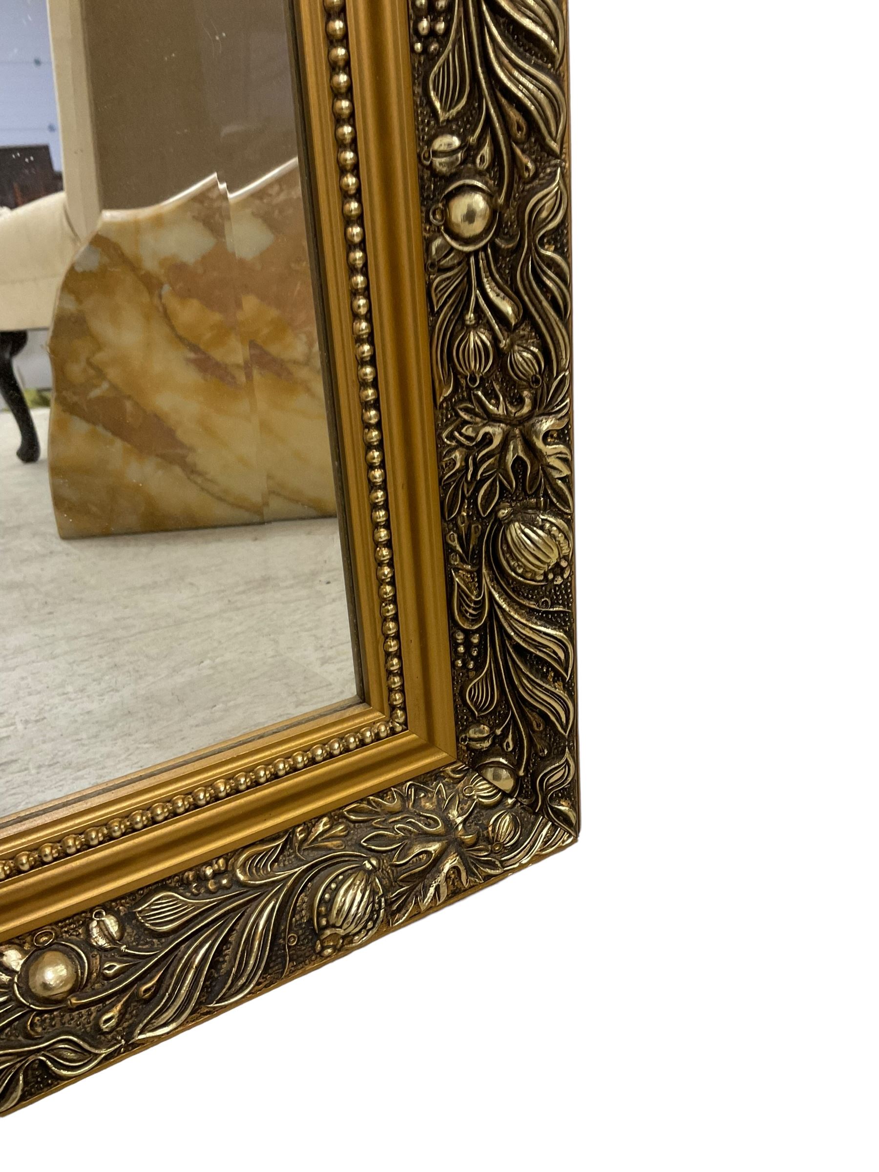 Large rectangular gilt framed wall mirror, decorated with trailing leafy branches and flowerheads, bevelled glass plate 