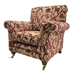 Contemporary upholstered armchair, scroll arms and loose cushions, embossed beige ground fabric with red and gold floral motifs, on tapered wooden supports with front brass castors