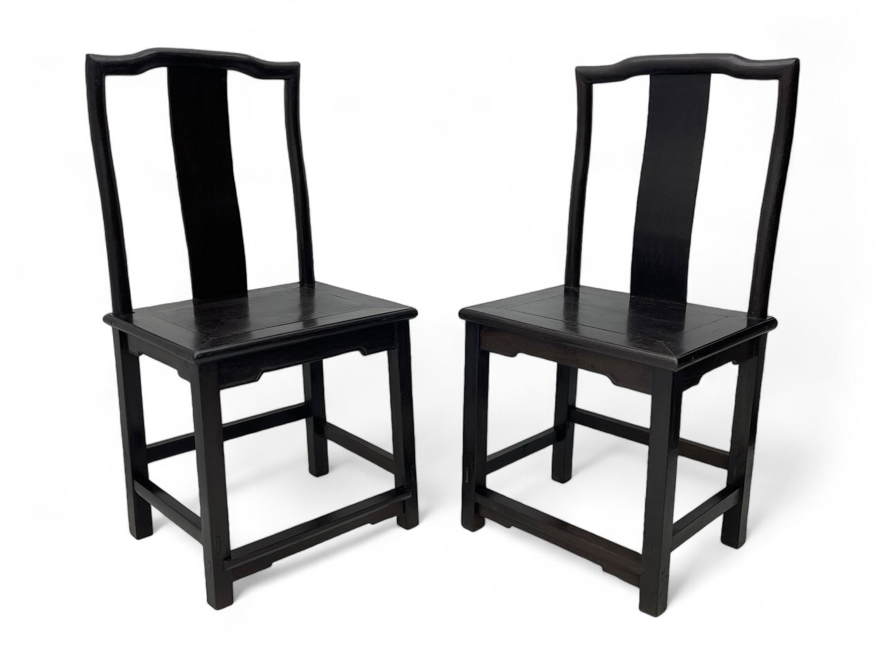 Pair of early 19th century Chinese Qing dynasty black wood side chairs, yoke cresting rail over shaped back panel, panelled rectangular seat on square supports united by stretchers 