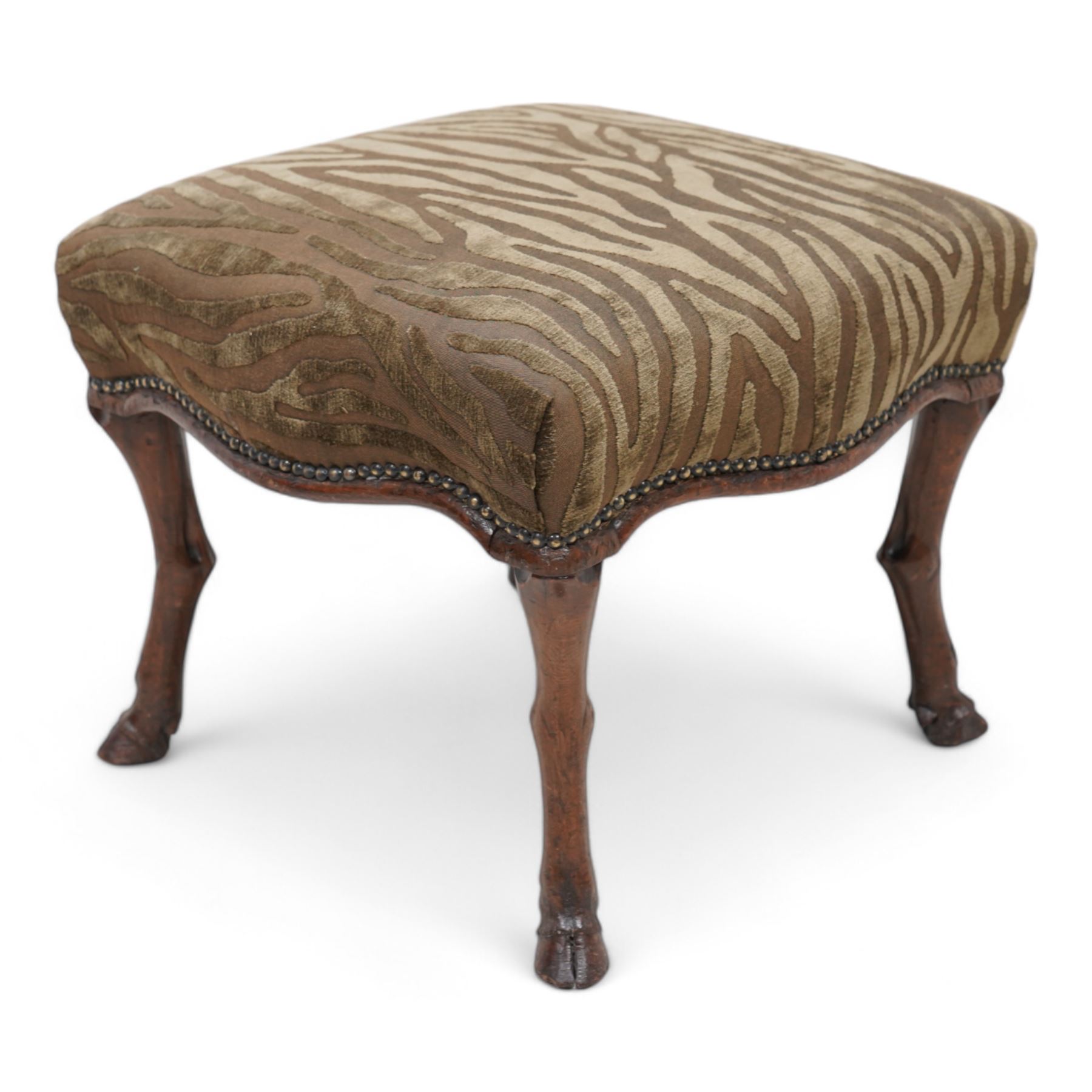 Victorian walnut footstool, the over-stuffed seat upholstered in dark green animal print fabric with stud band, on carved deer leg supports with hoof feet