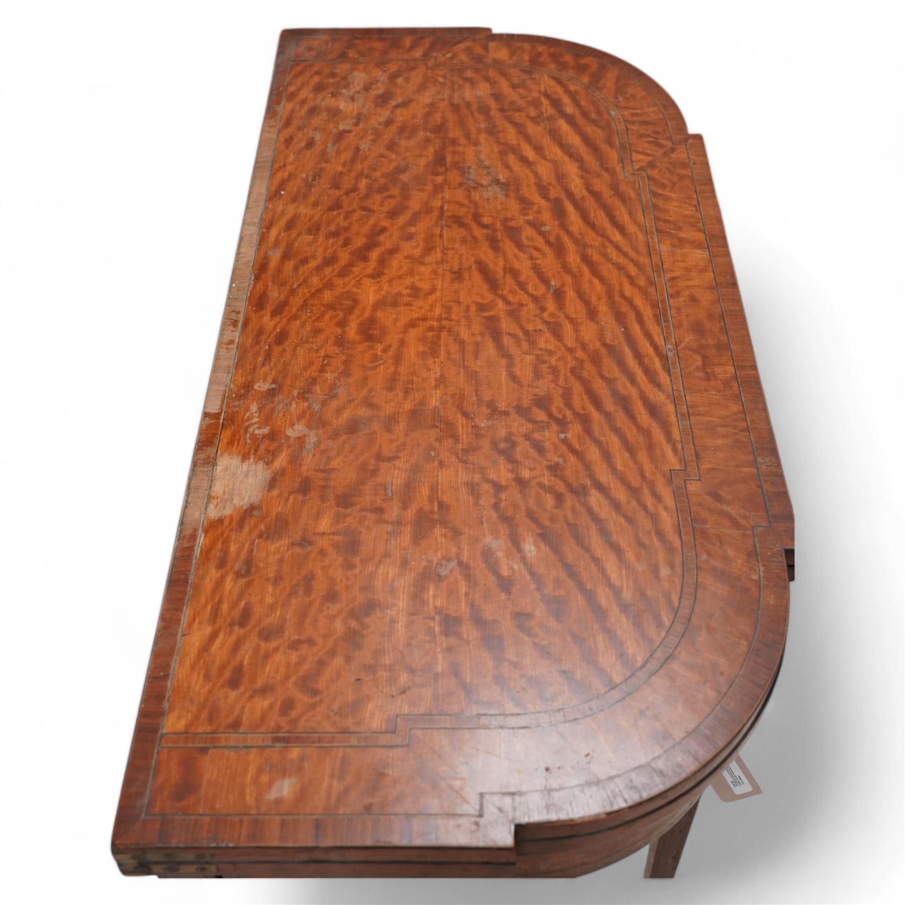 Sheraton period satinwood card table, stepped D-end form, fold-over top revealing baize playing surface, double gate-leg action base, on square tapering supports with peg feet 