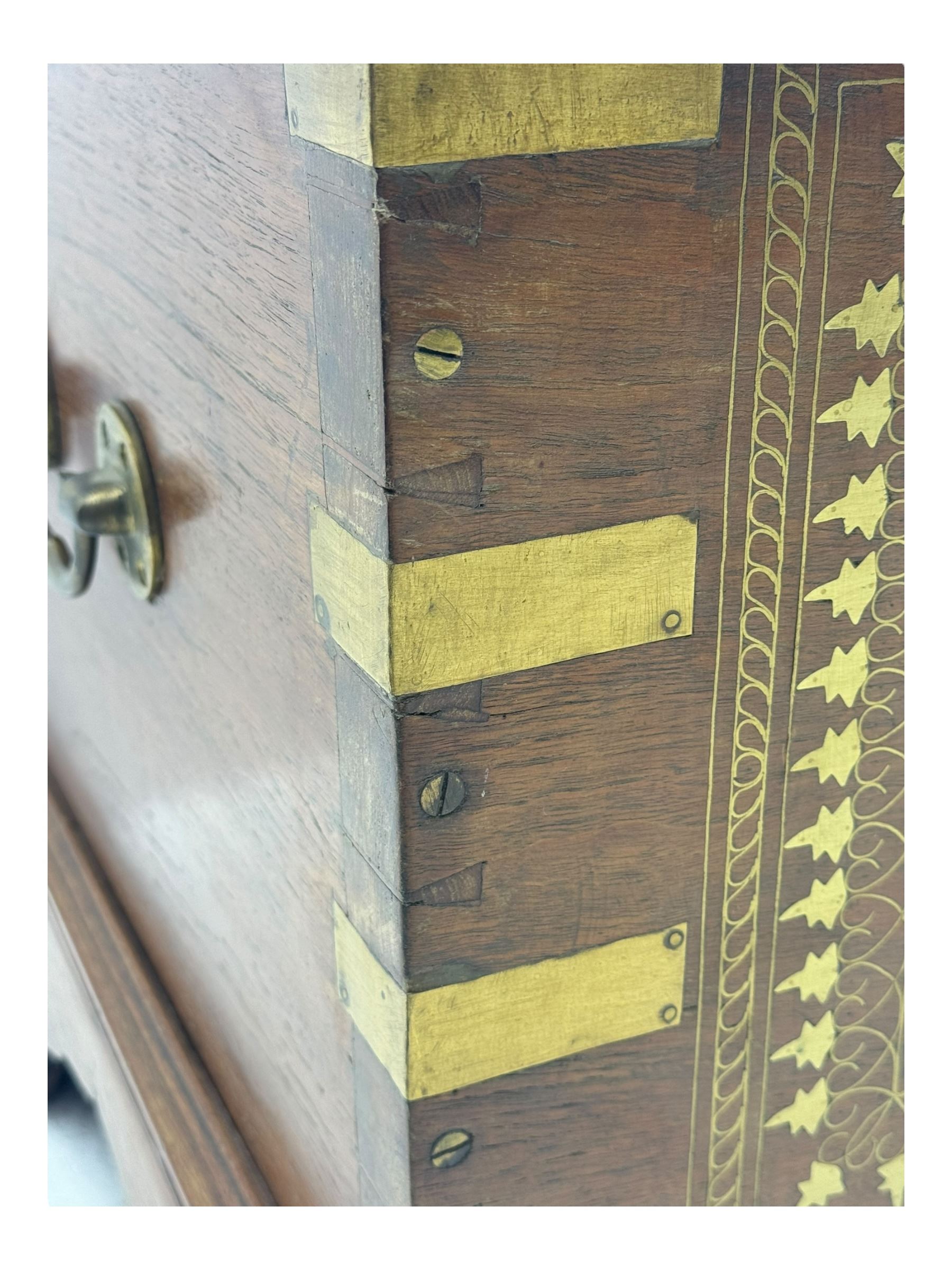 20th century mahogany chest, rectangular hinged top enclosing removable compartments with carved starburst motifs with linear and geometric patterns, brass inlay to the top and front, mounted corners and edges, on bracket base