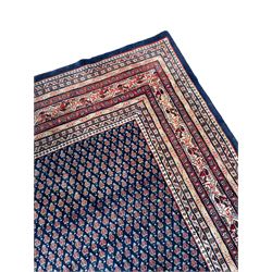 Large North-West Persian Arrak indigo ground carpet, the field decorated all-over with small Boteh motifs, multiple band border decorated with repeating geometric designs