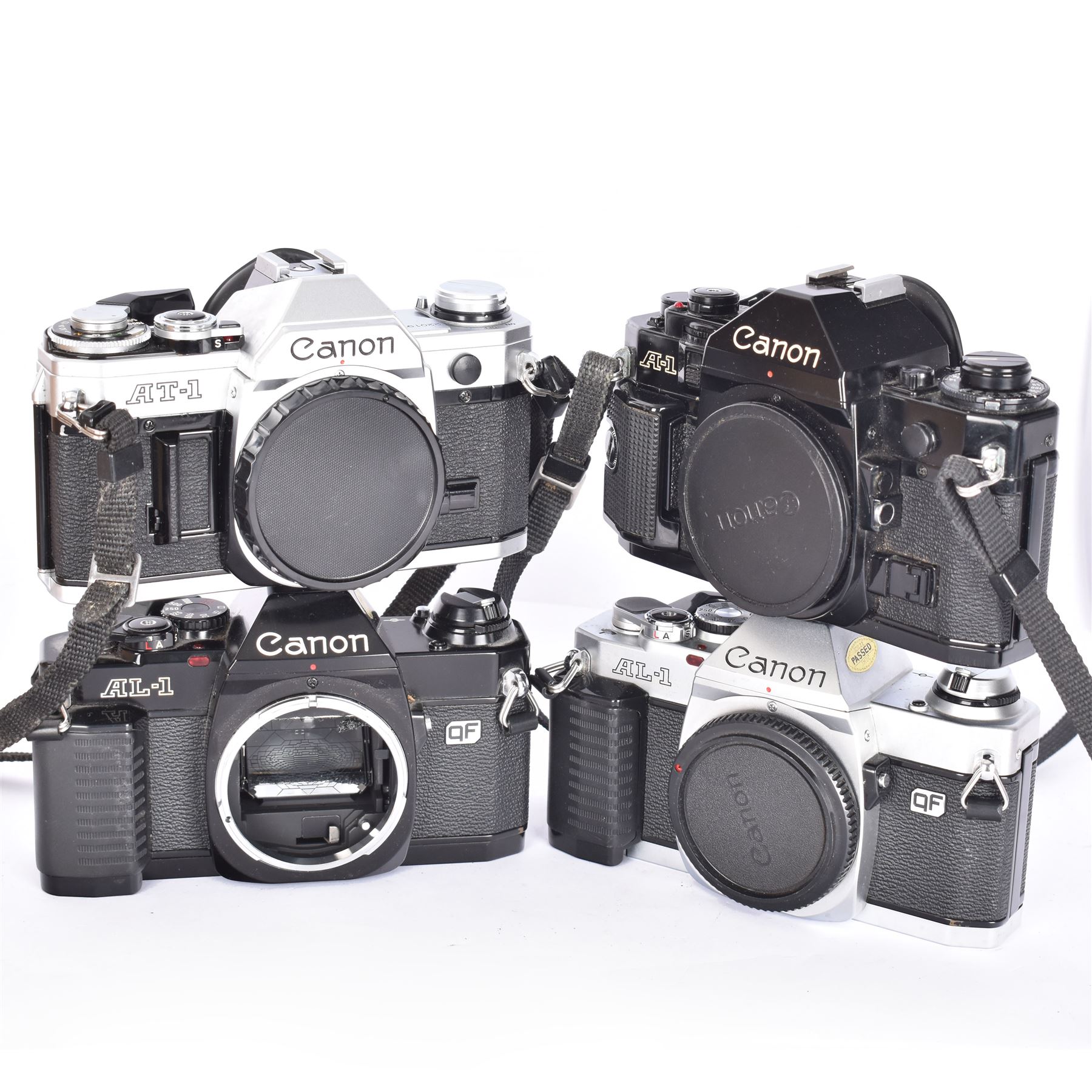 Four Canon SLR camera bodies, to include AT-1 in black and silver finish, serial no. 220197, A-1 in black, serial no. 508829, ad two AL-1 bodies, one black and one silver and black, serial nos. 1102614 & 3043913