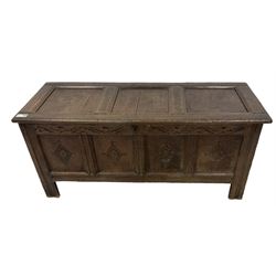 18th century oak coffer or chest, rectangular hinged panelled top with moulded frame enclosing candle box, the frieze carved with foliate S-scrolls over a quadruple panel front decorated with carved lozenges, on stile supports