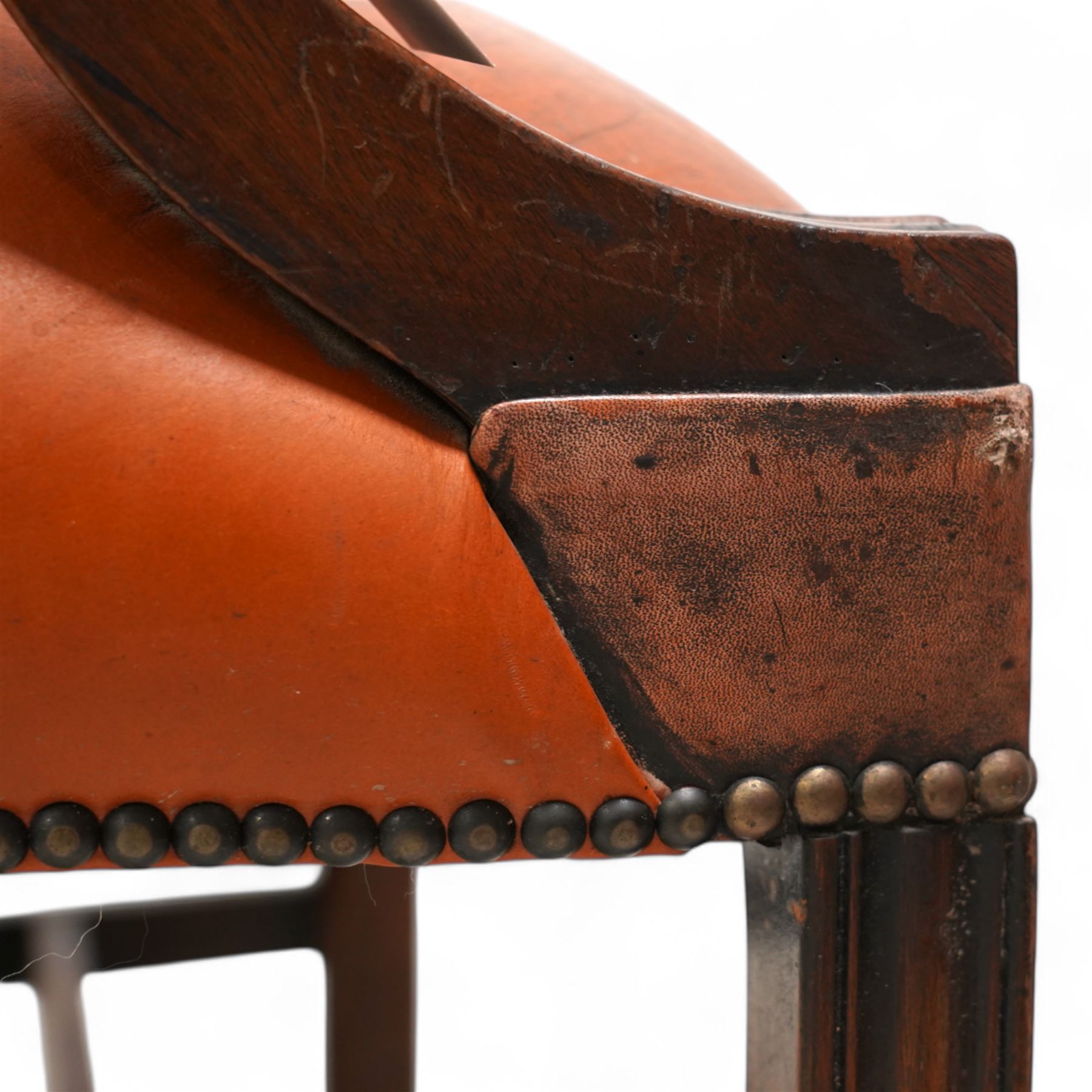 Georgian design Gainsborough elbow chair, upholstered in leather with studwork bands, moulded square supports united by H-stretcher, on brass castors 