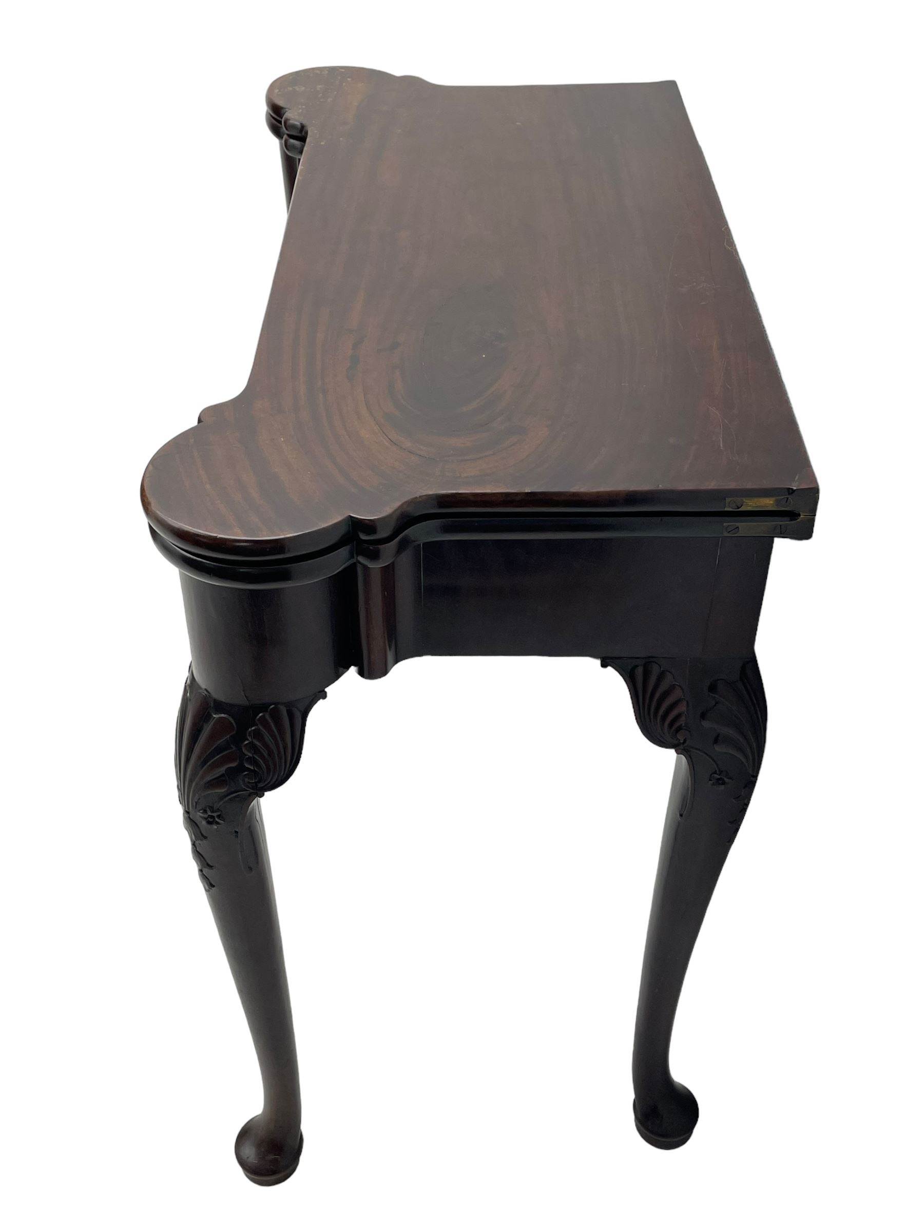 Late 18th century Irish mahogany tea table, rectangular form with projecting stepped rounded corners, fold-over action top over single frieze drawer within cock-beaded surround, on shell and bellflower carved cabriole supports, single gate-leg action base 