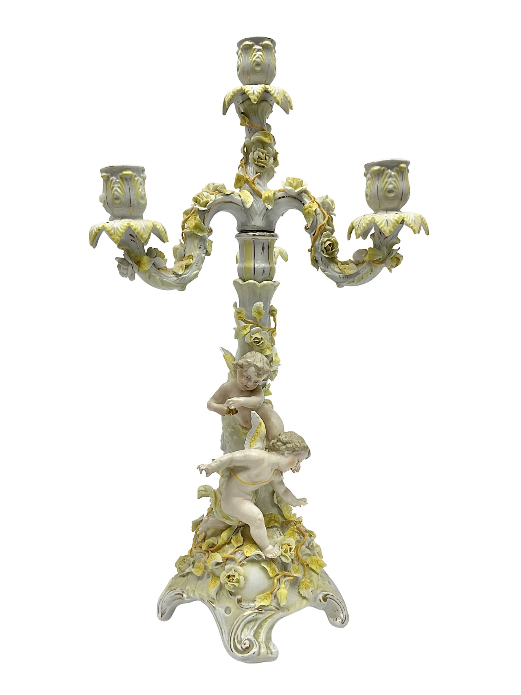 Dresden style candelabra, the central stem bordered by three branches, decorated with cherubs and yellow roses, H48cm