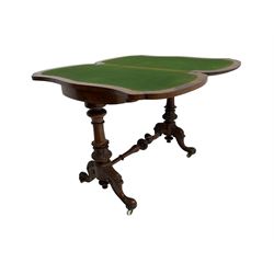 Late 19th century figured walnut card table, shaped hinged swivel top with scrolling satinwood inlay and shaped edge, raised on turned and fluted vasiform supports carved with foliate design united by turned stretcher, on splayed cabriole supports with scroll carving and ceramic castors