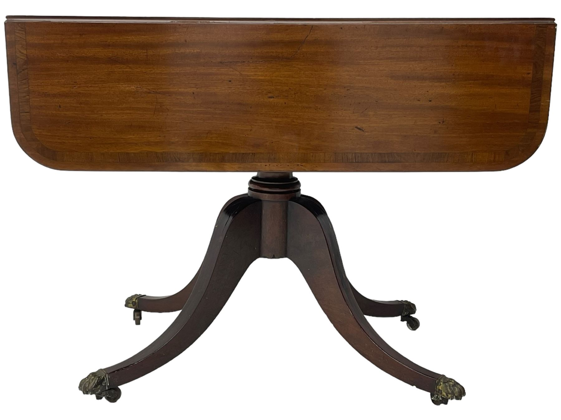 Early 19th century mahogany supper table, rectangular reed moulded drop-leaf top with rounded corners, fitted with single end drawer, on turned pedestal with four out-splayed supports with brass paw castors 