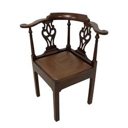 George III mahogany corner elbow chair, curved back rest and shaped arms with scroll carved terminals, on turned supports and pierced scroll carved interlaced splats, drop-in seat upholstered in brown leather, on square supports with inner chamfer and outer moulding 