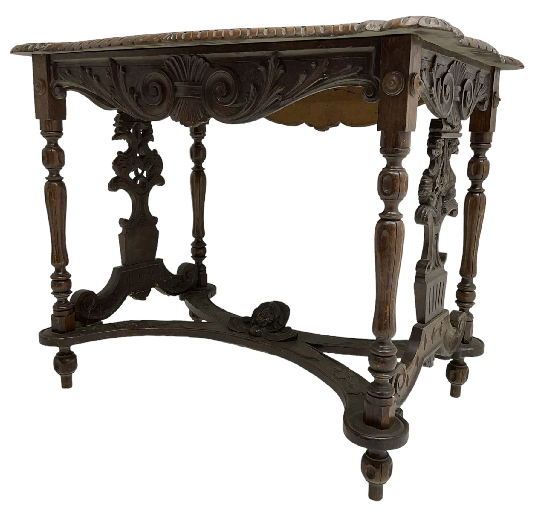 19th century walnut centre table, shaped top carved with central cartouche and extending scrolled foliage, the shaped frieze rails carved with scrolling acanthus leaves, turned supports with central end supports carved with flower heads and scrolls, curved x-framed stretcher carved with a central mask depicting a girl in a bonnet, on turned and carved feet