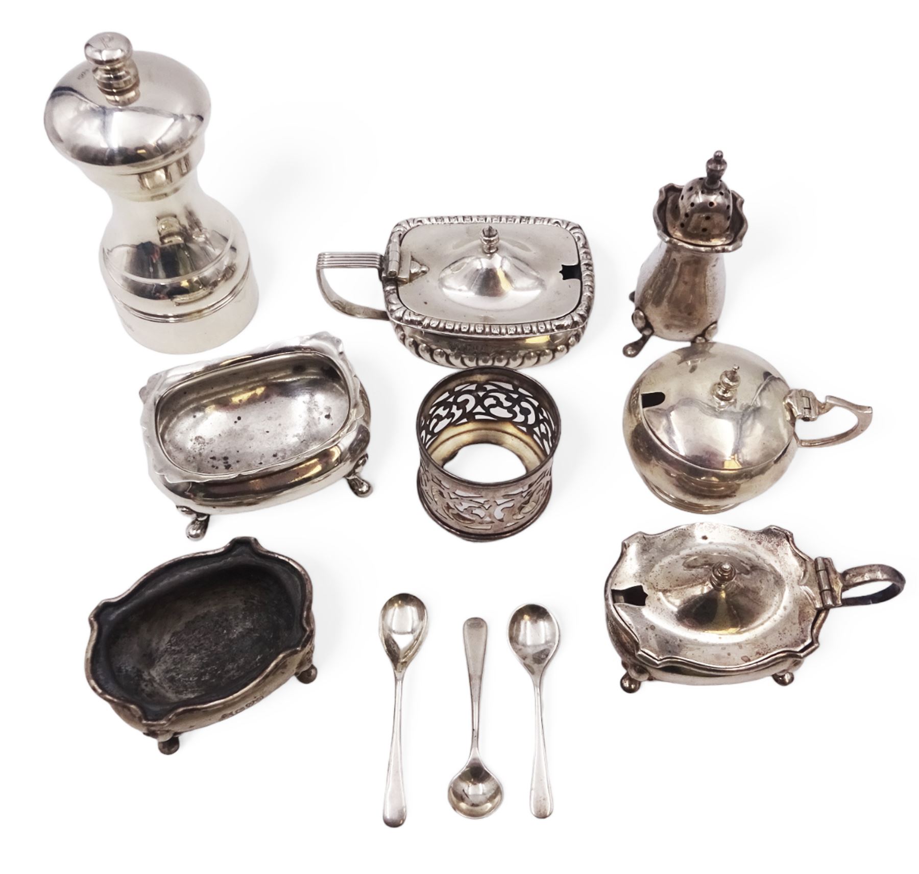 Group of silver cruet items, including two mustard pots, silver mounted pepper grinder, open salts, spoons, etc, all hallmarked 